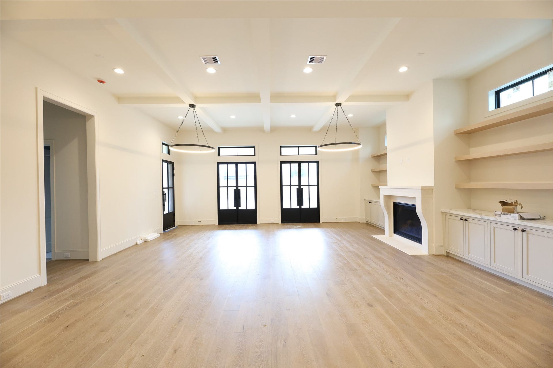 752 W 43rd Street, Houston, TX 77018 Spacious Family Room offers 12' ceilings, ceiling beam detail, gas fireplace, transom windows and several metal frame doors leading to the covered patio and back yard.