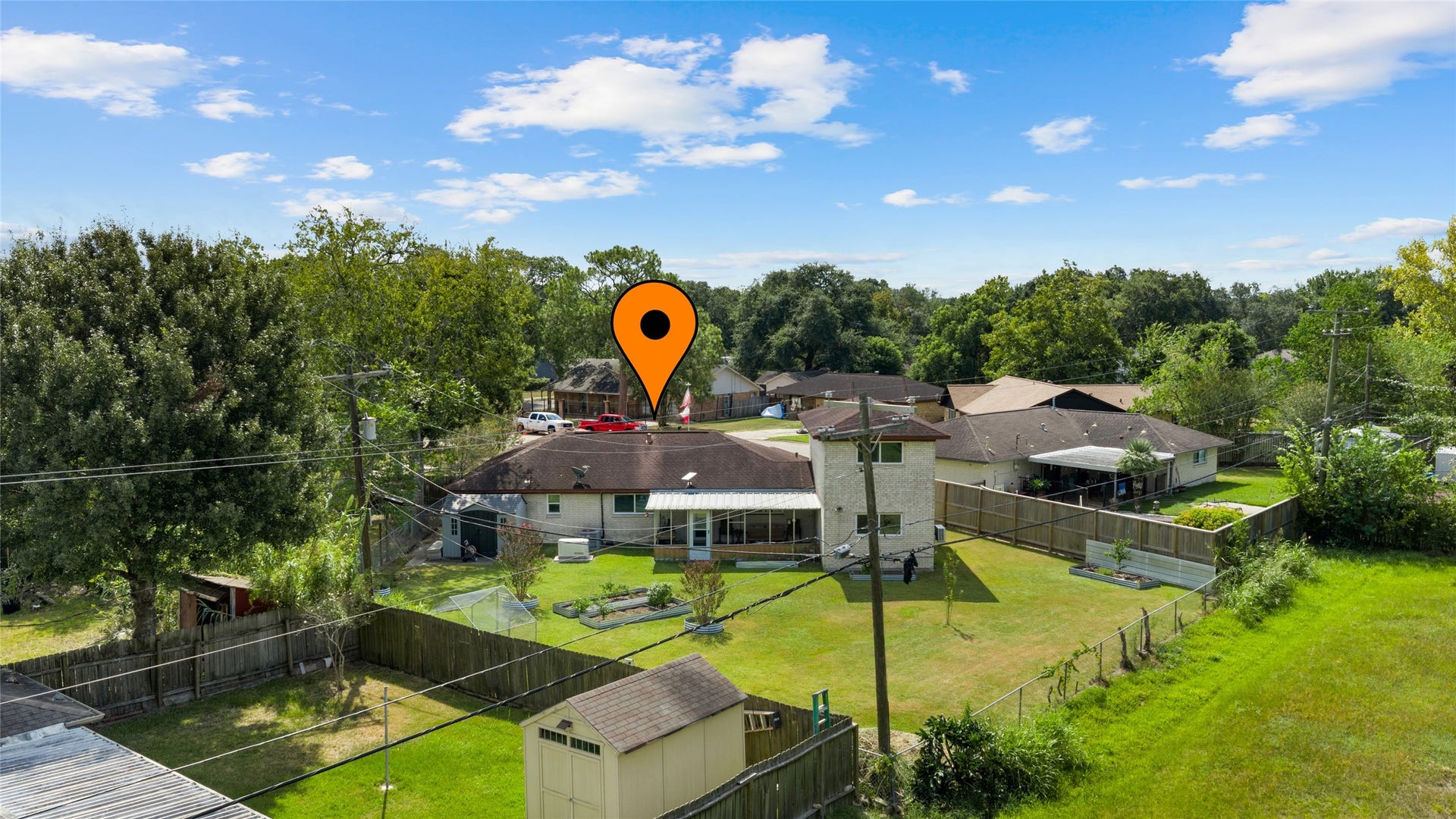 503 Allen Court, Alvin, TX 77511 Aerial view showcases the homes expansive backyard with plenty of open green space, raised garden beds, storage shed, and covered screened patio.