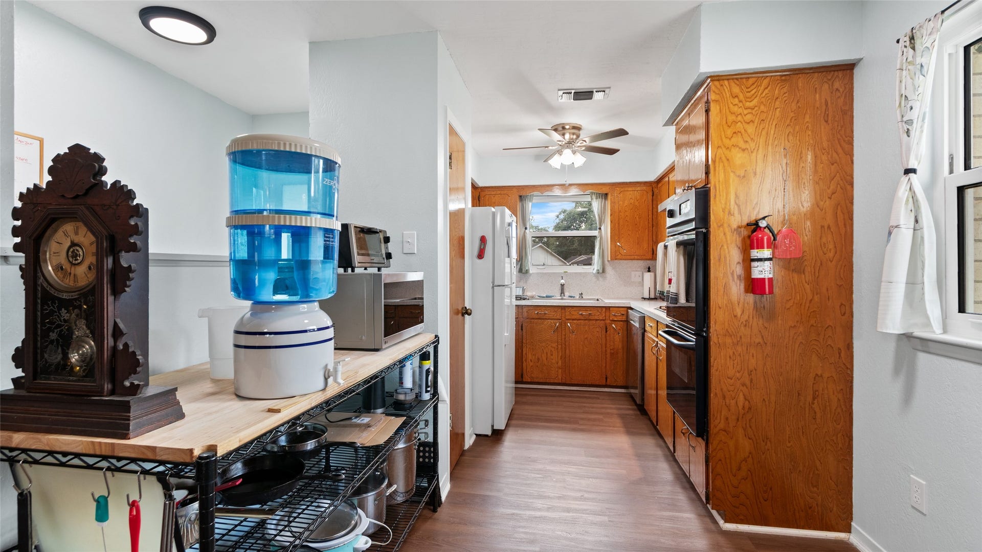 503 Allen Court, Alvin, TX 77511 Galley-style kitchen offers abundant cabinetry, generous workspace, wood-look flooring, and multiple windows providing natural light.