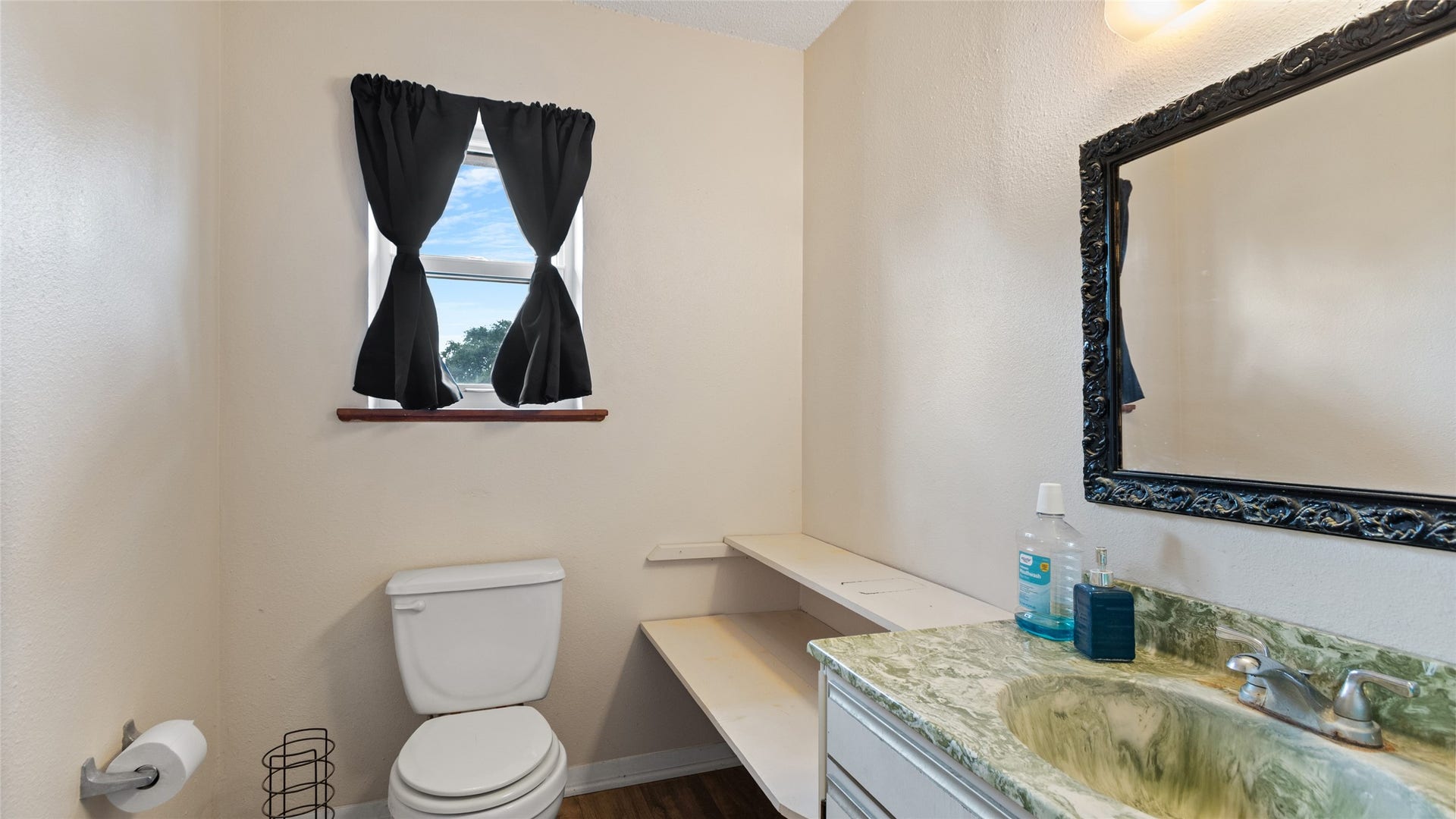 503 Allen Court, Alvin, TX 77511 Another view of the private bath, featuring a vanity with generous counter space, built-in open shelving for convenient storage, and a window for natural light.