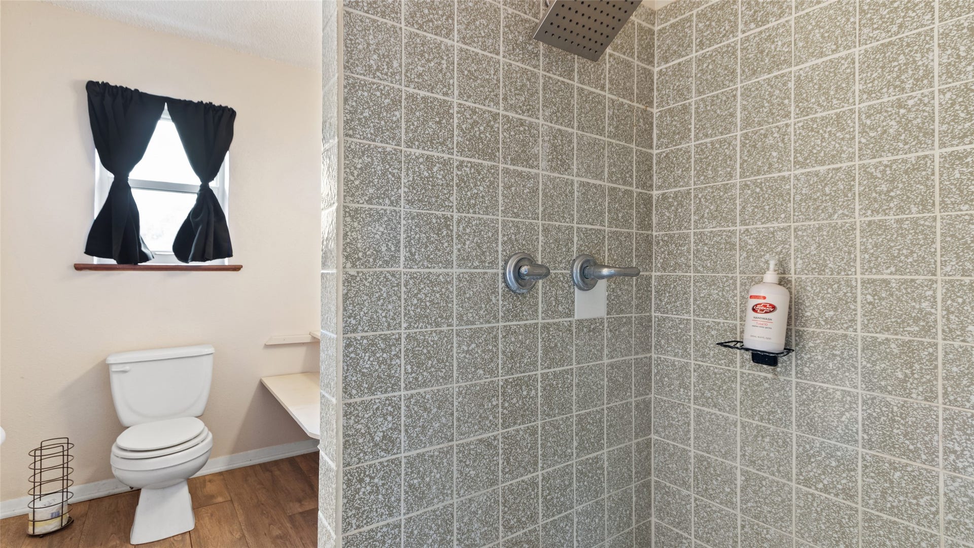 503 Allen Court, Alvin, TX 77511 Private bath featuring a tiled walk-in shower with rainfall showerhead and a window providing natural light.