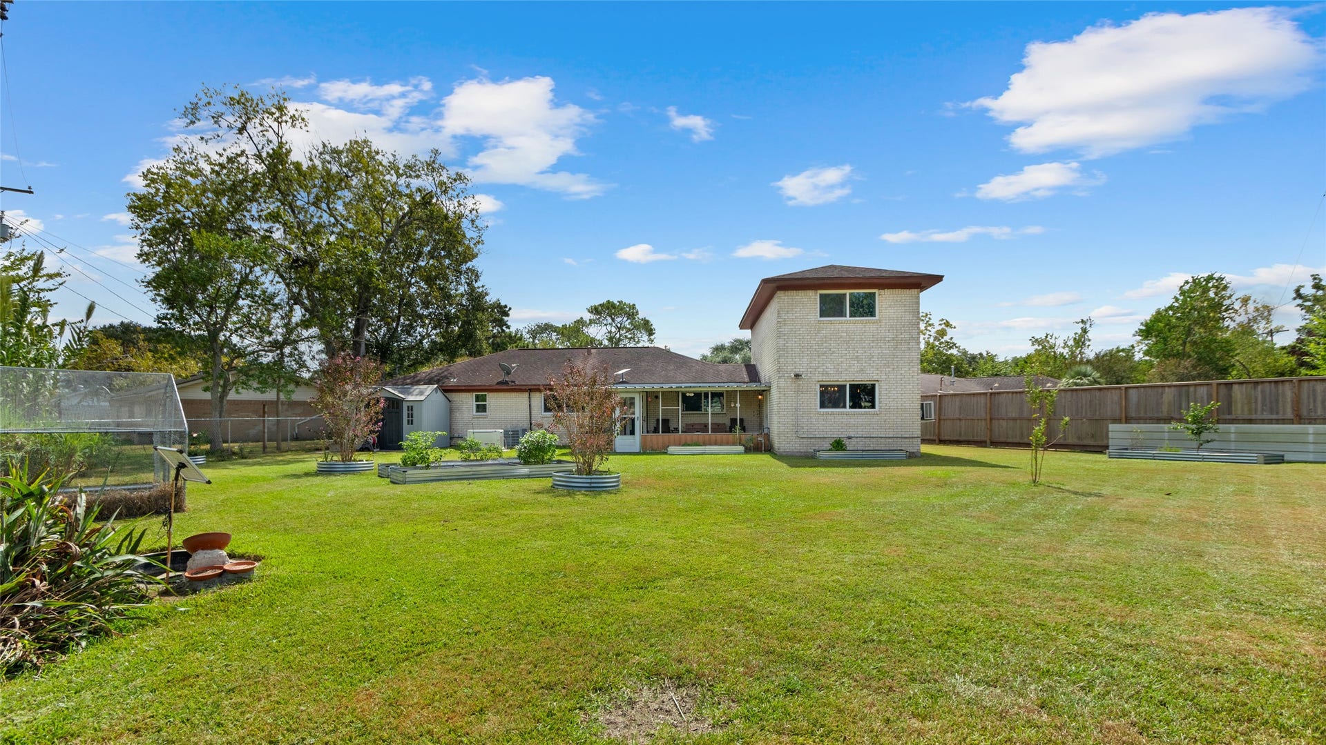 503 Allen Court, Alvin, TX 77511 Wide backyard view highlights the homes generous outdoor space, raised garden beds, greenhouse, and screened-in patioplenty of room to garden, entertain, play, or simply enjoy the outdoors.