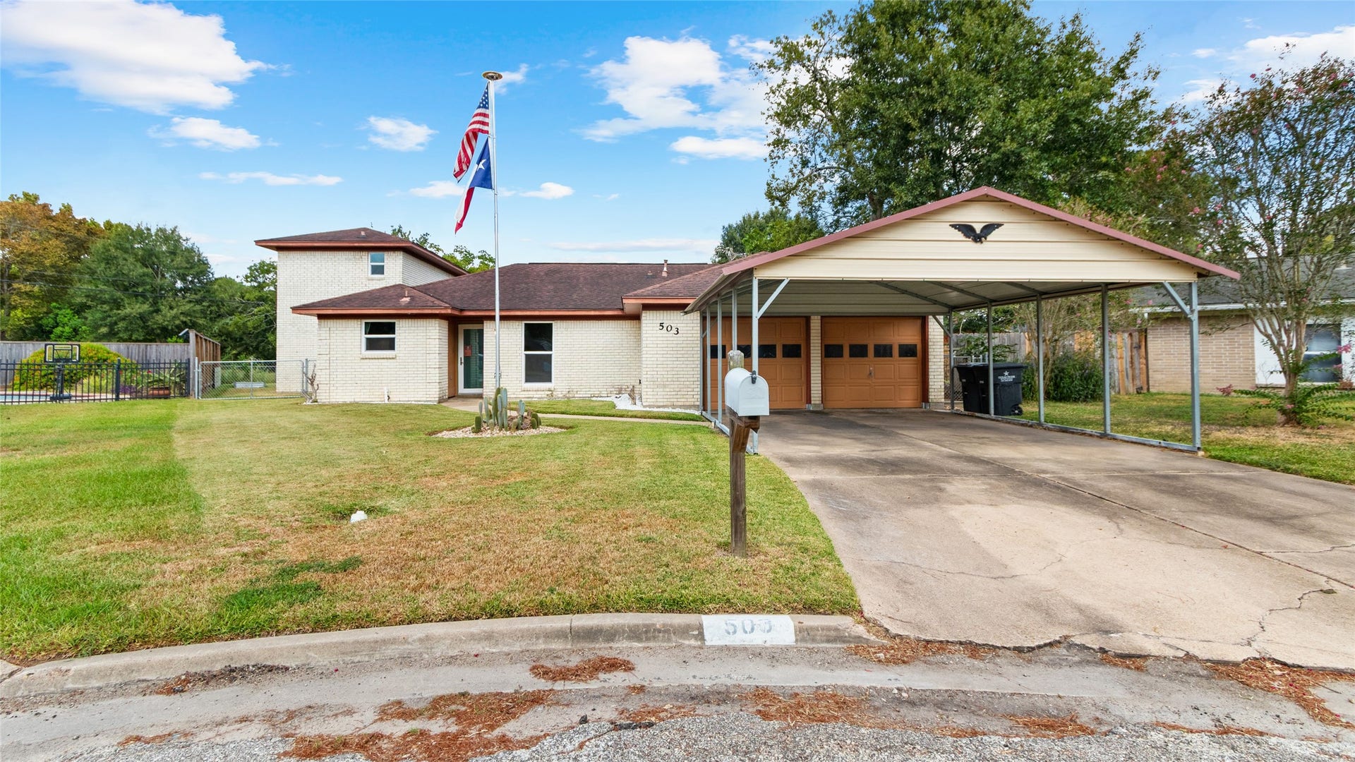 503 Allen Court, Alvin, TX 77511 Front exterior view showcases the homes distinctive multi-level design, attached garage, and extended covered carport providing ample off-street parking.