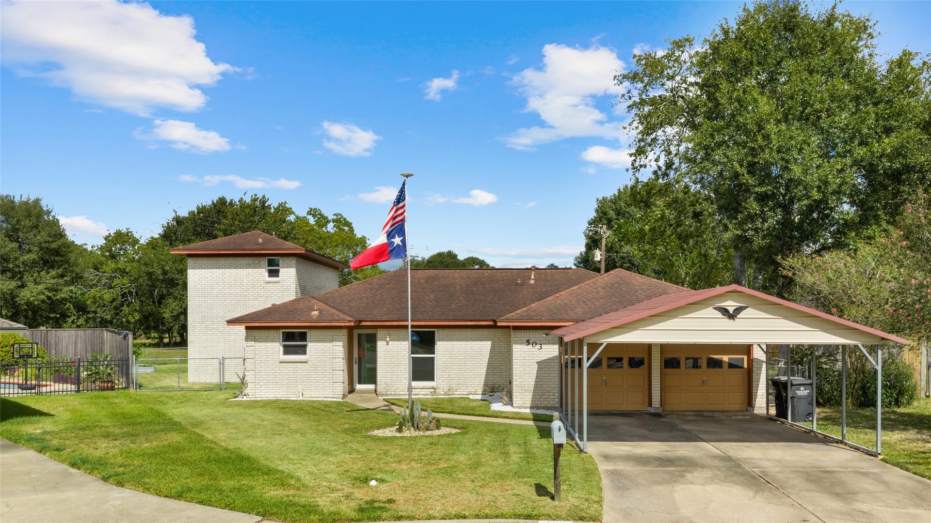 503 Allen Court, Alvin, TX 77511 Charming brick home with a welcoming front lawn, attached two-car garage, additional covered parking, and gated access to the backyard.