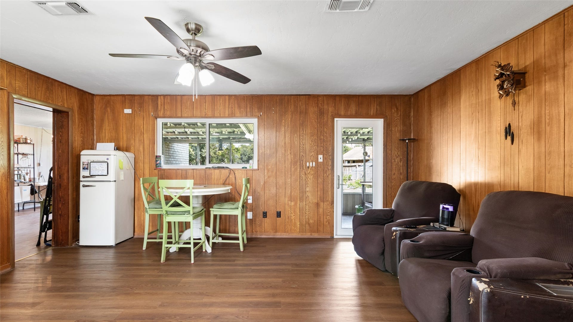 503 Allen Court, Alvin, TX 77511 Generously sized living area features wood-look flooring, a ceiling fan, and direct access to the covered outdoor space and backyard.
