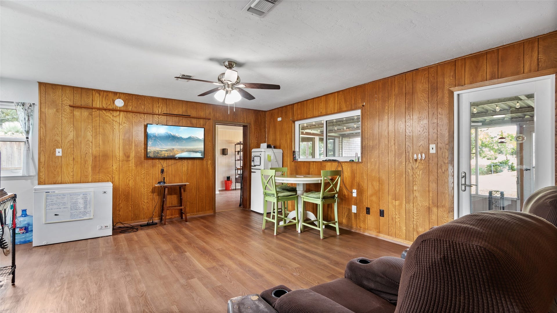 503 Allen Court, Alvin, TX 77511 Alternate view of the living area highlights its generous proportions, durable wood-look flooring, abundant natural light, and easy access to the covered outdoor living space.