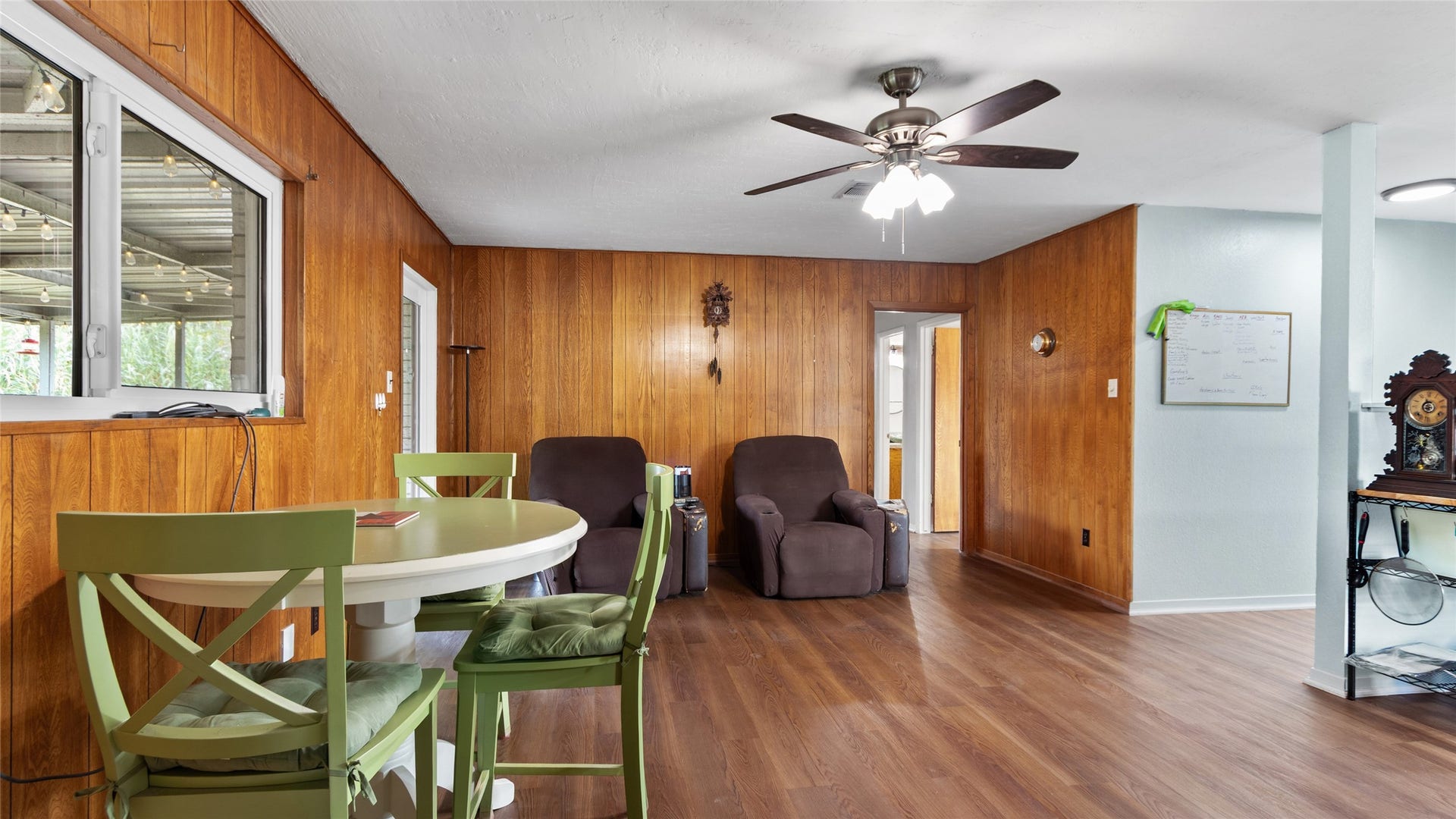 503 Allen Court, Alvin, TX 77511 Additional view highlights the versatile living space, wood-look flooring, ceiling fan, and large interior window connecting the room visually to the covered outdoor area.