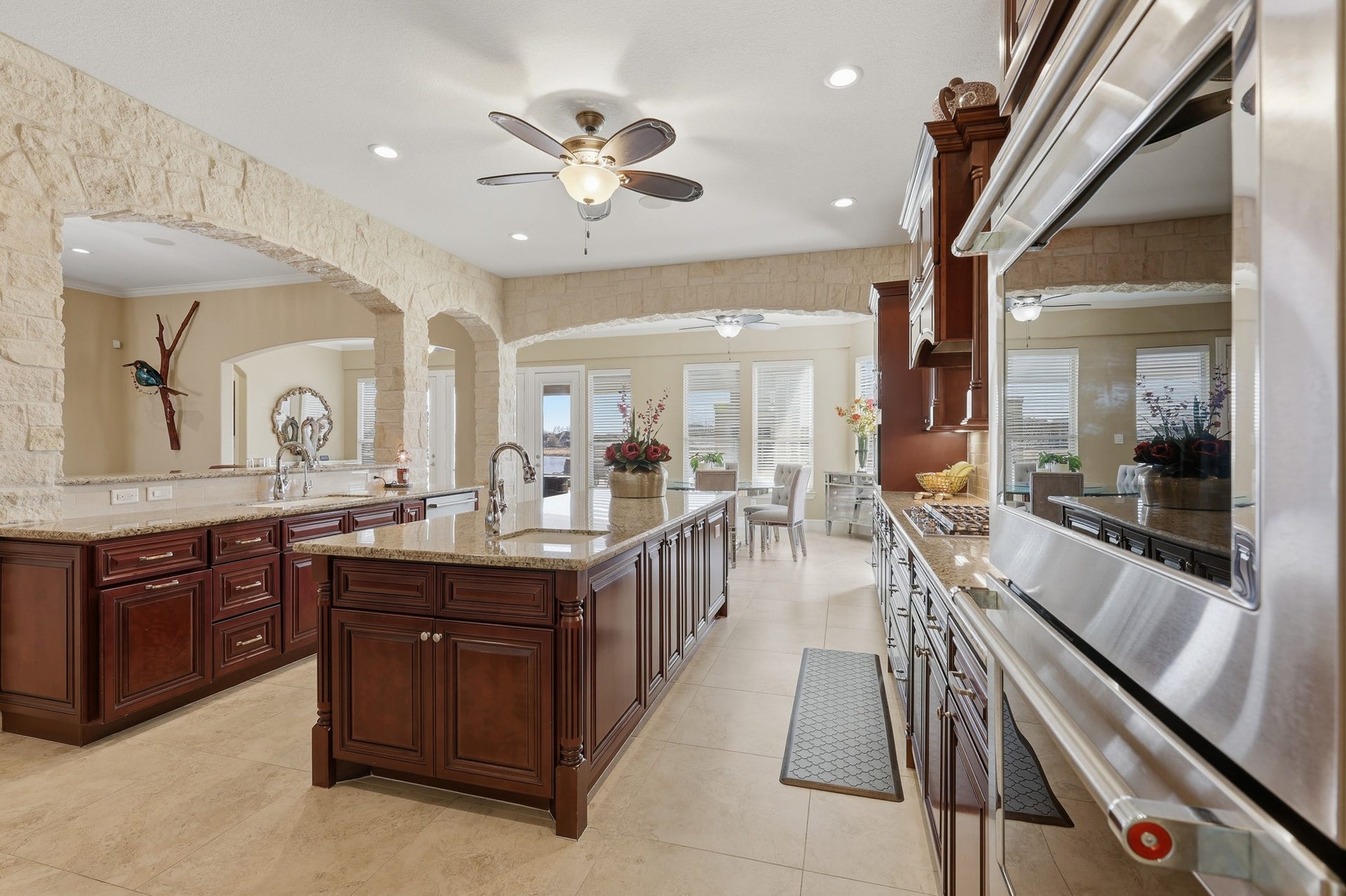 An extraordinary gourmet kitchen designed for both grand entertaining and everyday living. he oversized island anchors the space, while elegant stone archways add architectural distinction and timeless appeal.
