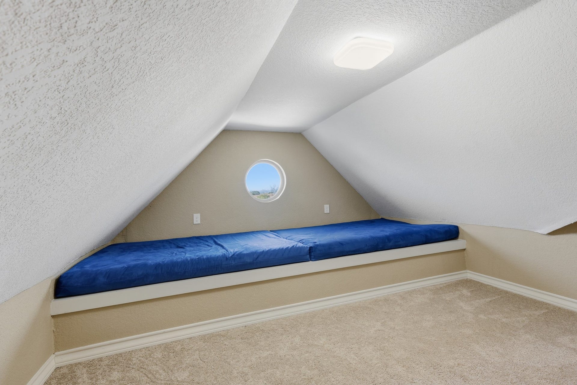 A charming architectural alcove with a round feature window adds character and versatility to this upper-level space. The built-in nook provides a cozy reading or lounging area, while the surrounding open layout allows for a creative studio, study zone, or additional living space.