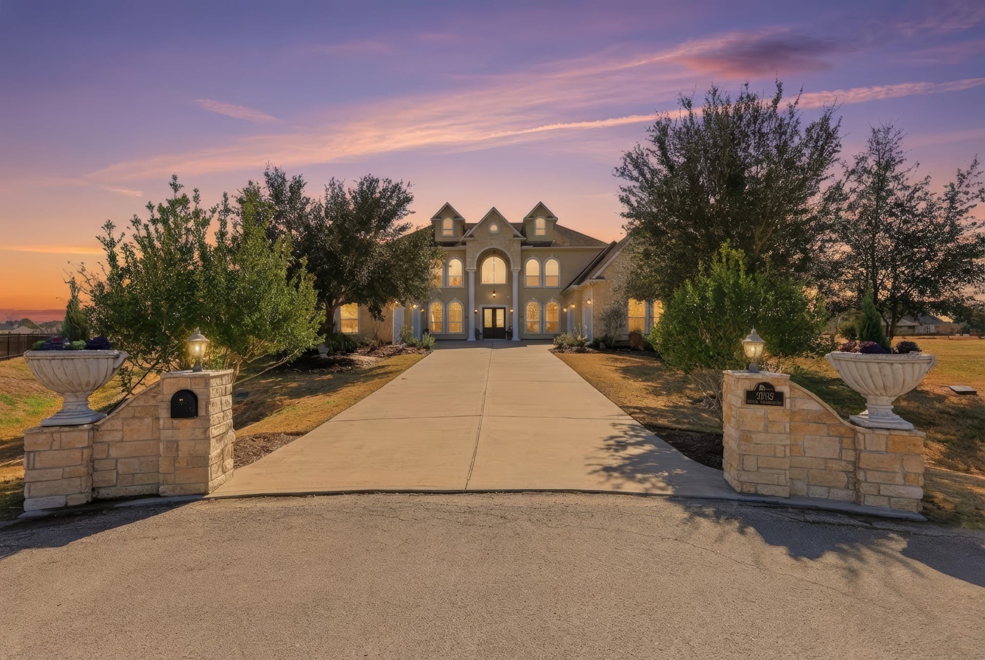 A grand, private approach welcomes you home with a long, sweeping driveway framed by elegant stone pillars and mature landscaping. Set on an expansive homesite, this impressive estate offers a stately presence, exceptional privacy, and a true luxury arrival experience.