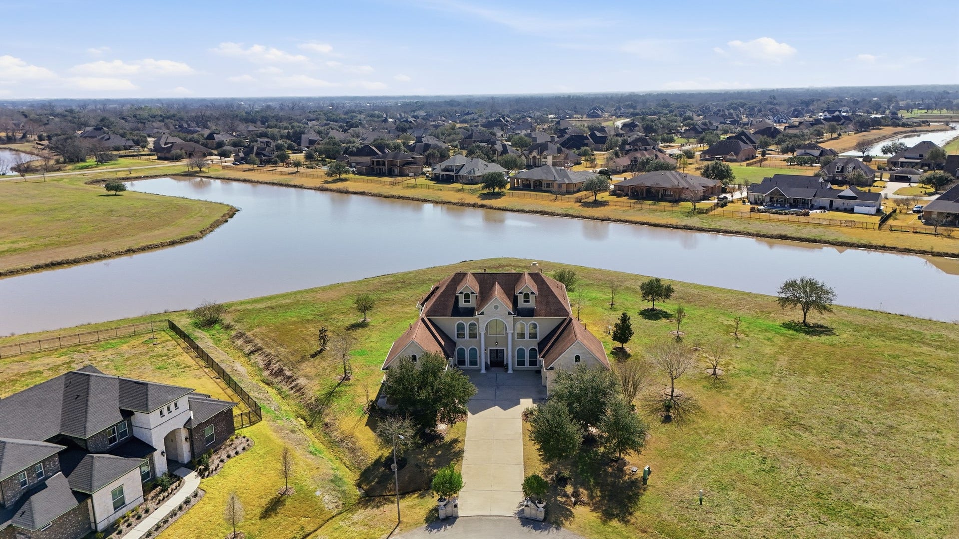 This stunning custom residence showcases timeless architecture with a beautiful stone and stucco faade, arched windows, and a dramatic two-story entry. Symmetrical design, manicured grounds, and mature trees create unforgettable curb appeal. Multiple oversized garage bays offer exceptional storage and flexibility for car enthusiasts, recreational vehicles, or additional workspacean ideal complement to this estates expansive design.