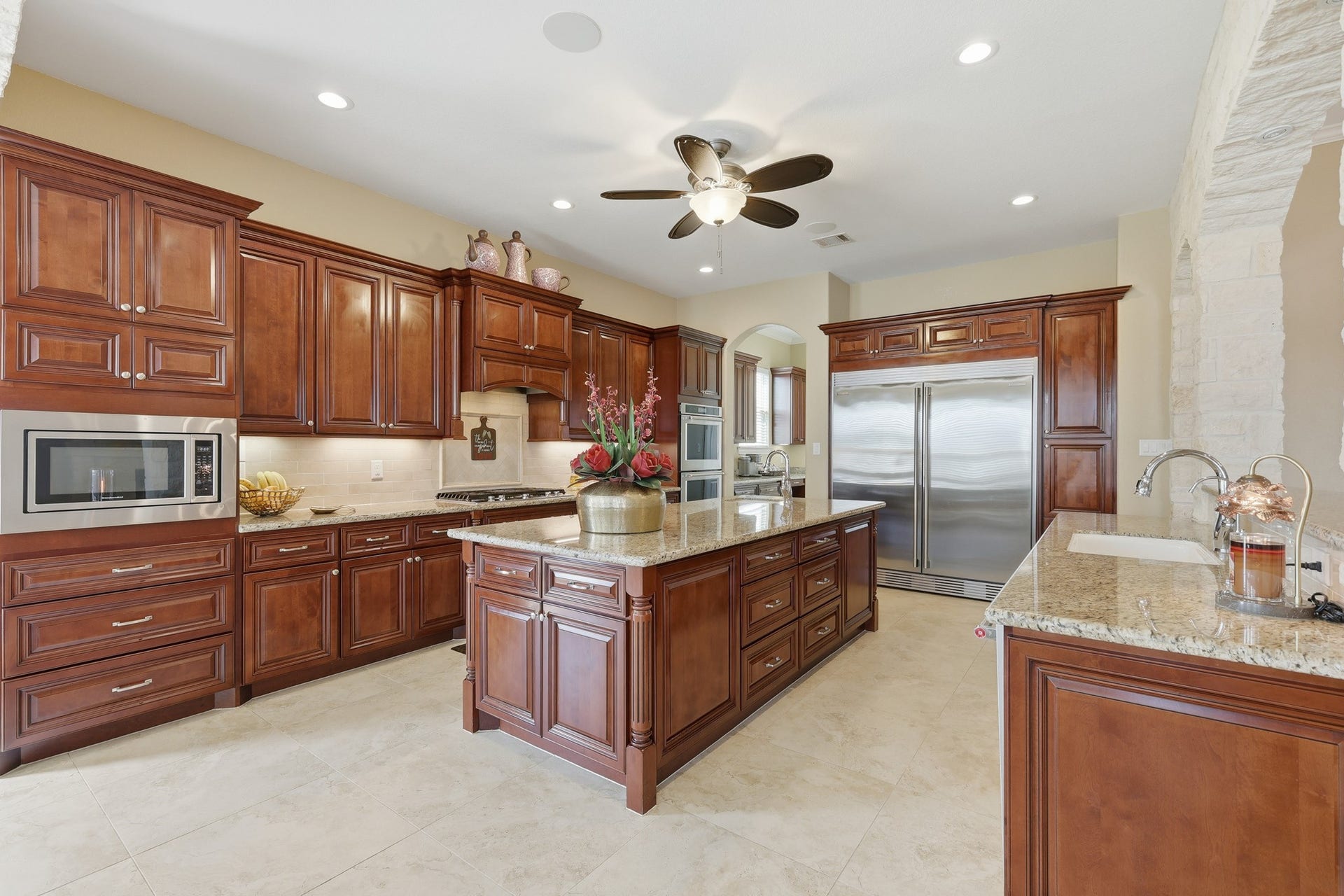 Expansive granite countertops, custom wood cabinetry, and professional-grade double ovens, 5 burner gas cooktop, microwave, and double-sided Electrolux Icon refrigerator create a harmonious blend of luxury and performance.