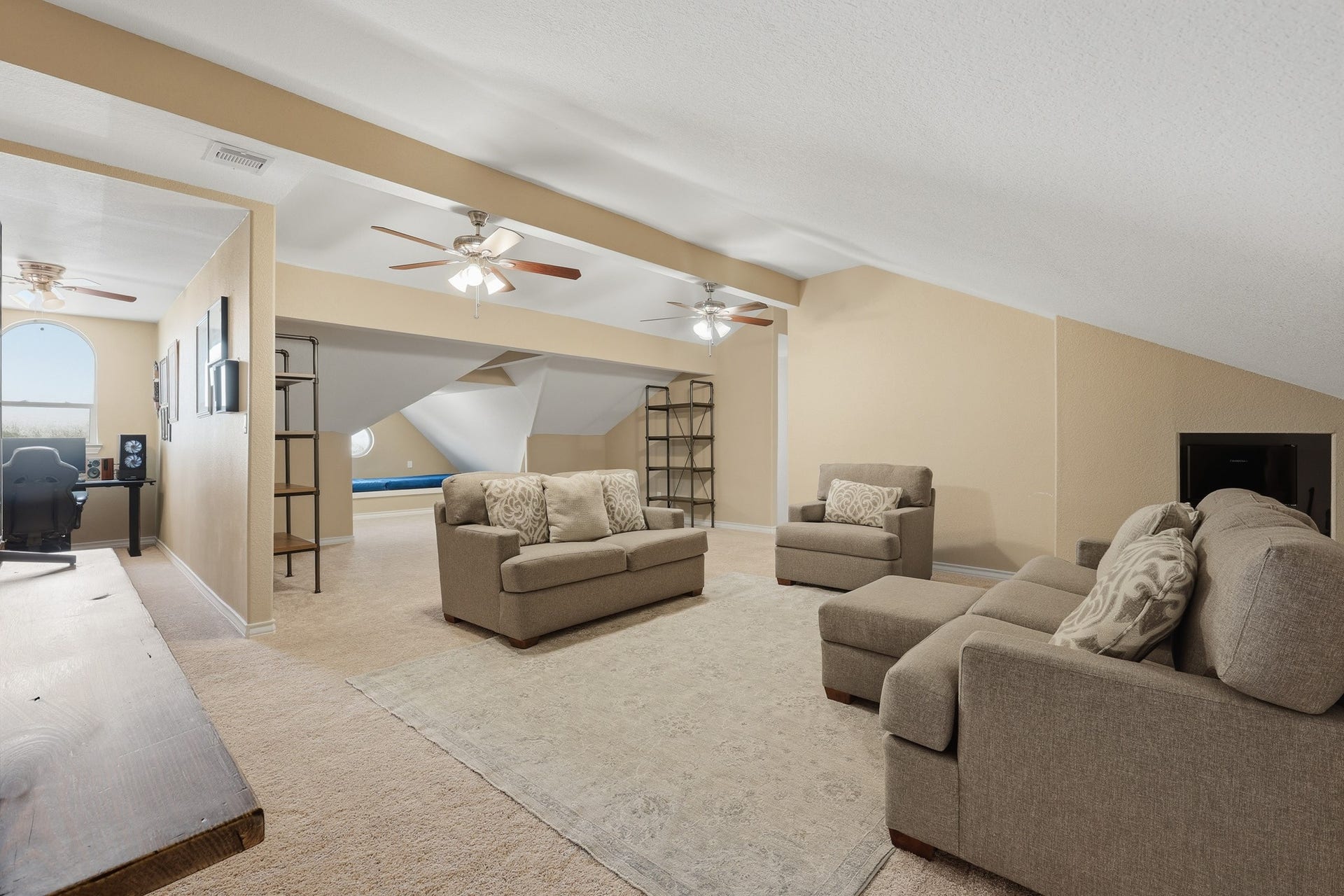 Perched on the third level, this expansive loft offers a private retreat ideal for a media lounge, game room, or executive hideaway. Vaulted ceilings and dual ceiling fans enhance the open, airy ambiance, while the generous layout allows for multiple seating arrangements and entertainment zones.