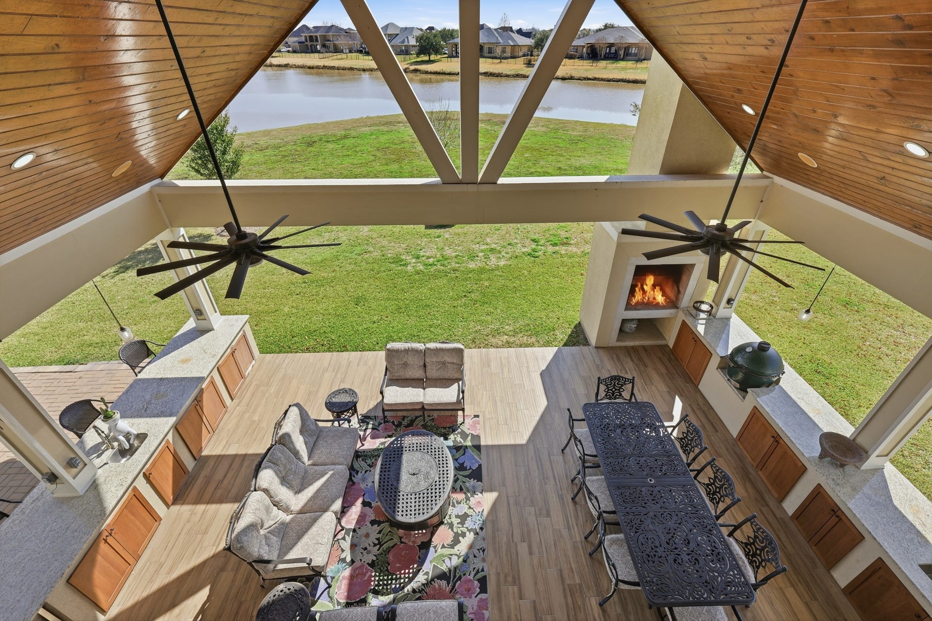 Overlooking the tranquil backyard and shimmering pond, this expansive covered balcony offers breathtaking elevated views and a private outdoor retreat.