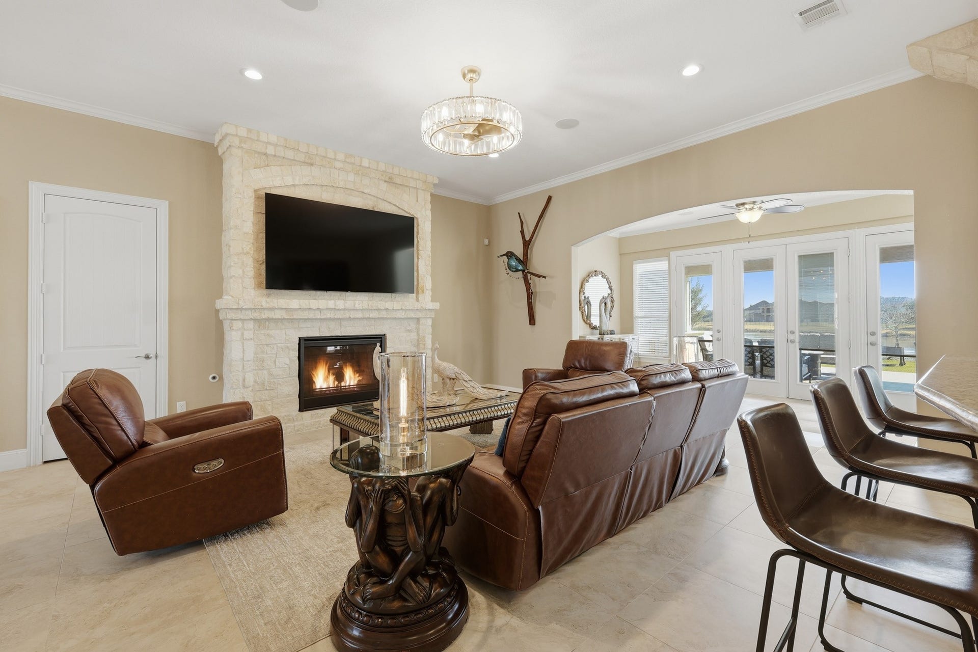 Expansive glass doors invite abundant natural light while showcasing serene backyard and pond views, enhancing the homes tranquil ambiance.