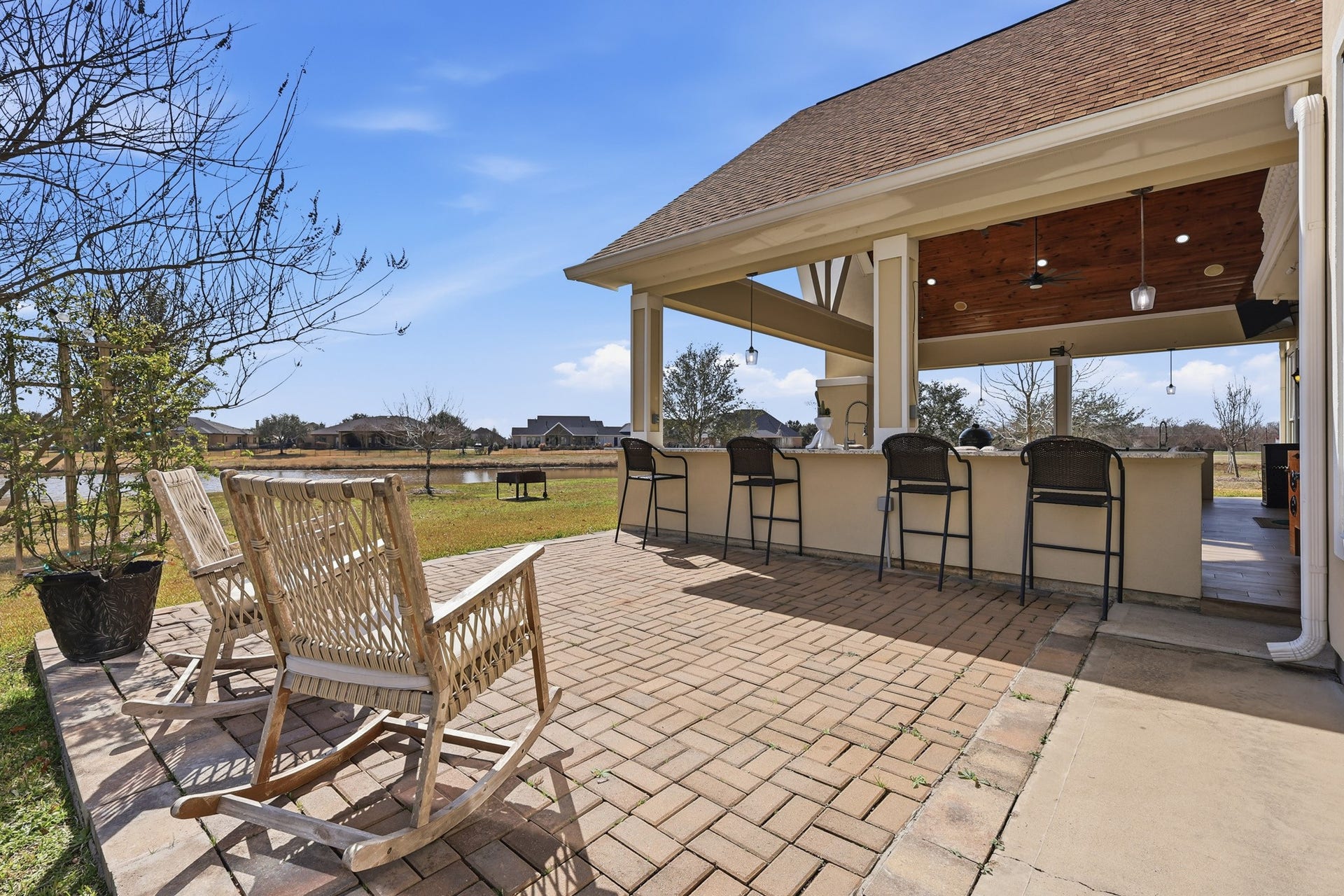 Beyond the covered pavilion, a beautifully paved patio extends the entertainment possibilities. A raised outdoor bar with seating invites casual conversation, morning coffee, or sunset cocktailsall framed by open skies and peaceful waterfront scenery.