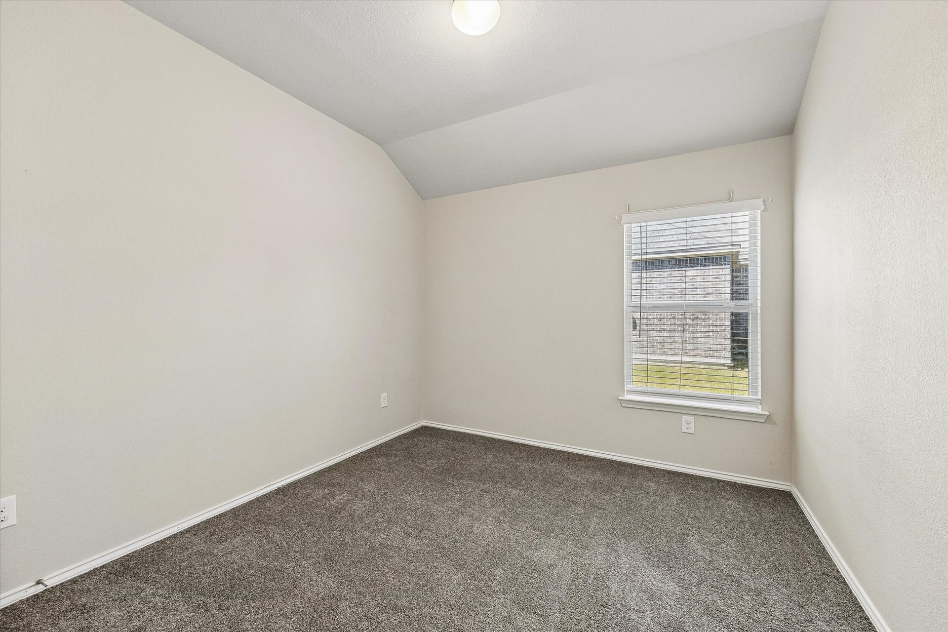 111 Valiant Ridge Trail, Magnolia, TX 77354 A versatile secondary bedroom offers natural light and a neutral palette, ready to accommodate bedroom furnishings or a home office setup.