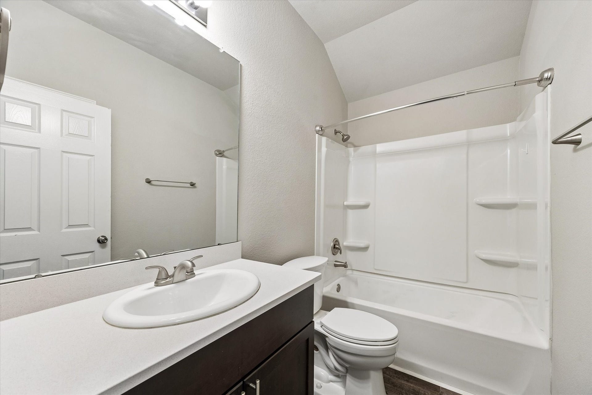 111 Valiant Ridge Trail, Magnolia, TX 77354 The secondary bathroom features a tub and shower combination, a large vanity mirror and cabinet storage beneath the sink.