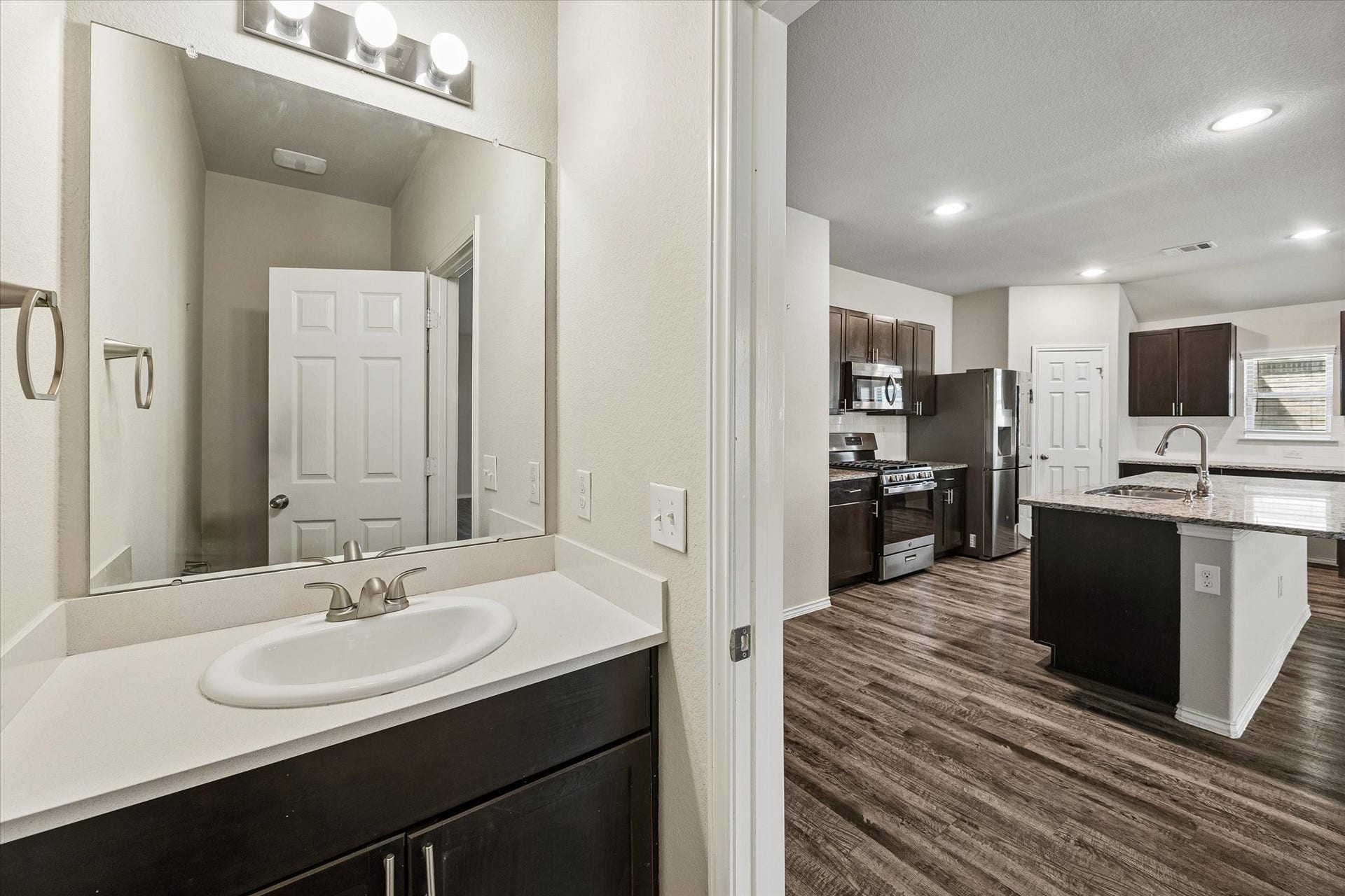 111 Valiant Ridge Trail, Magnolia, TX 77354 Conveniently located near the main living area, the half bath features a vanity with storage, a large mirror and neutral finishes.