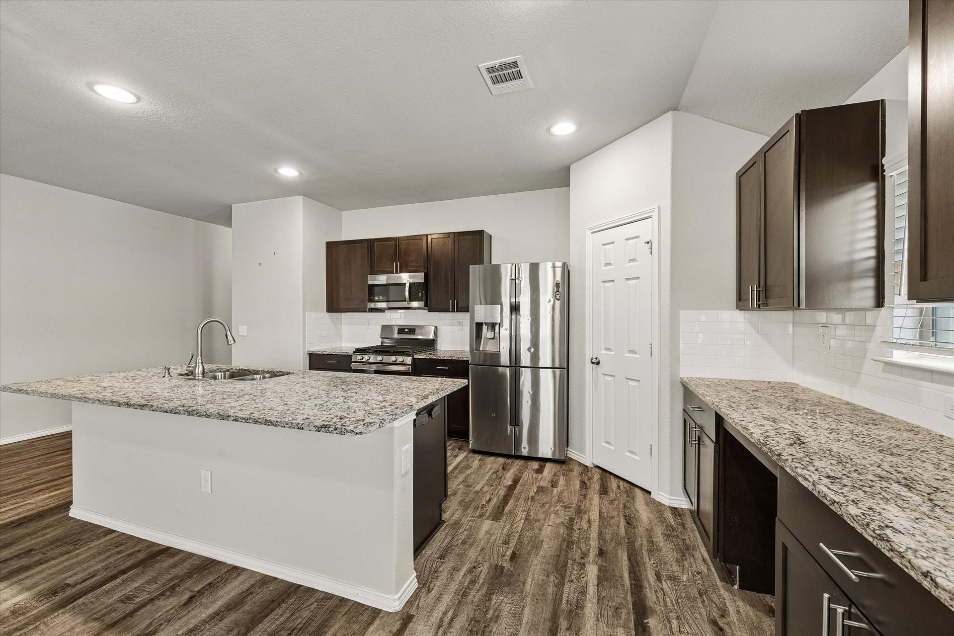 111 Valiant Ridge Trail, Magnolia, TX 77354 Enjoy ample counter space, a subway tile backsplash and a large island with an undermount sink. Additional cabinetry and a built-in work surface offer convenient storage and flexibility.