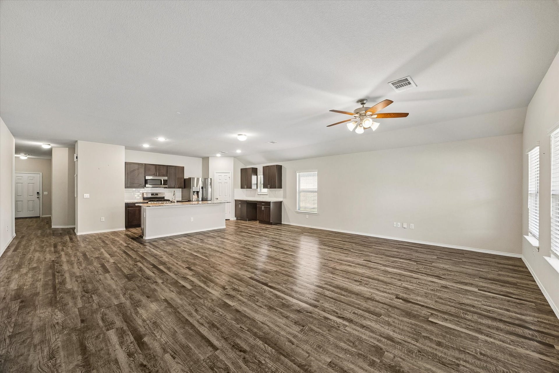 111 Valiant Ridge Trail, Magnolia, TX 77354 Beautiful wood-look flooring flows throughout the spacious main living area. The open layout connects the living room and kitchen, creating a welcoming space for everyday living and entertaining.