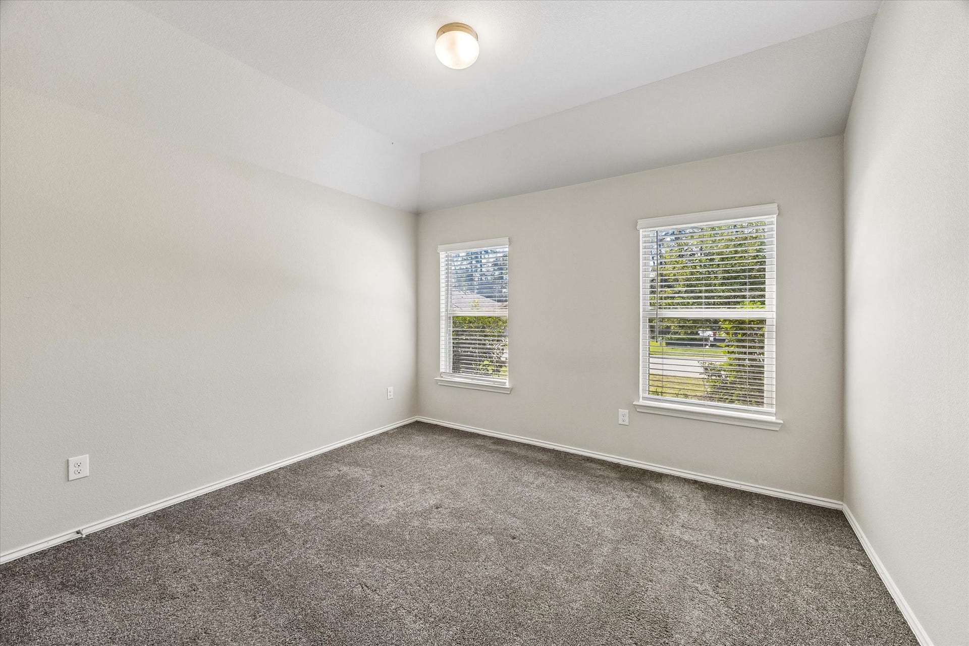 111 Valiant Ridge Trail, Magnolia, TX 77354 This bright secondary bedroom features two windows, soft carpeting and neutral walls, offering a comfortable space with plenty of decorating possibilities.