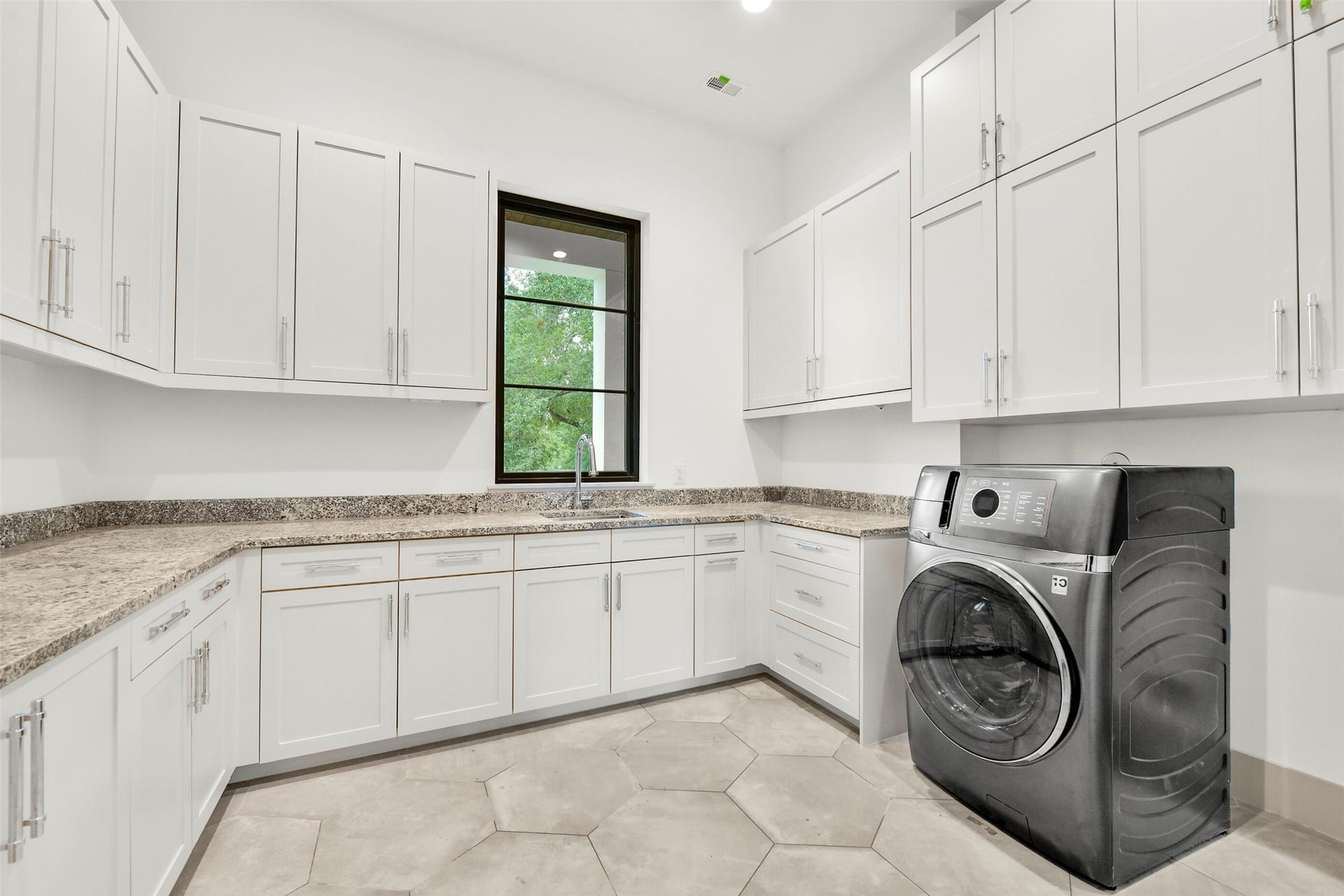A single unit washer/dryer is installed. Imagine loading your close into one machine setting it to wash then dry and coming back to a finished load of laundry. Incredible storage and ample counter space for folding and organizing your clothing. The lower cabinet to the left has direct access from the primary closet so you can drop your clothes directly into the utility room.