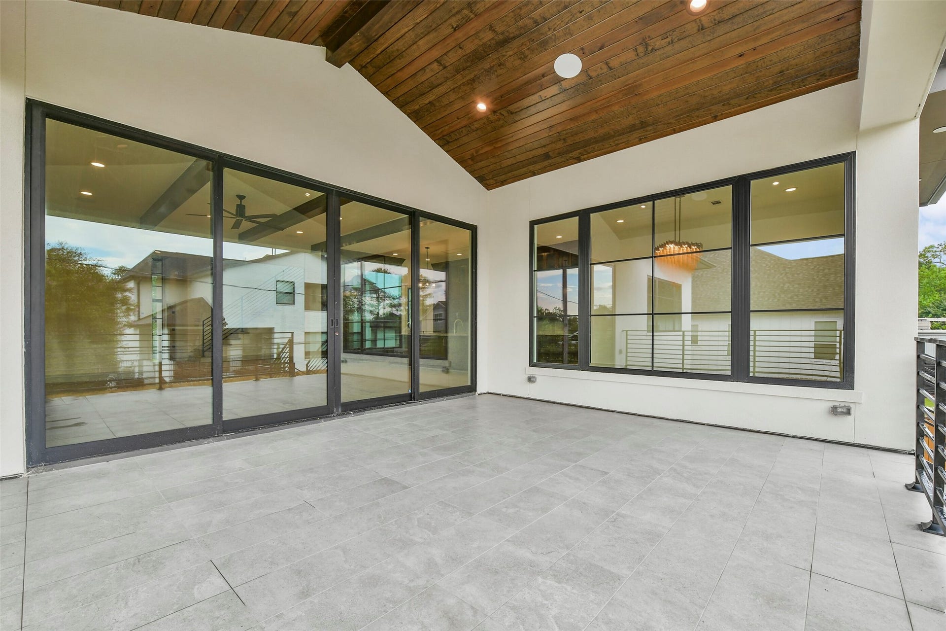 The large veranda off the family room also views the formal dining room. This 18X16 patio is perfect for enjoying the outdoors under cover with plenty of space for seating and a dining table. There are stairs to the right leading to the 1400 square foot covered patio, summer kitchen and large back yard.