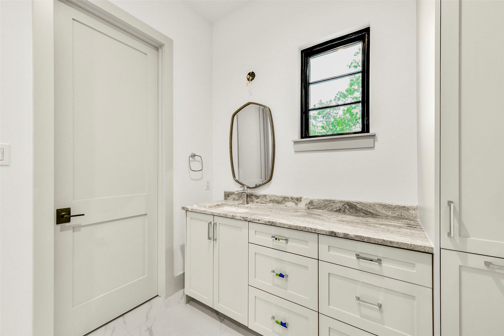 Secondary bedroom en-suite bathroom with large walk-in closet. The elegant shower with frameless glass door is to the left of the closet.