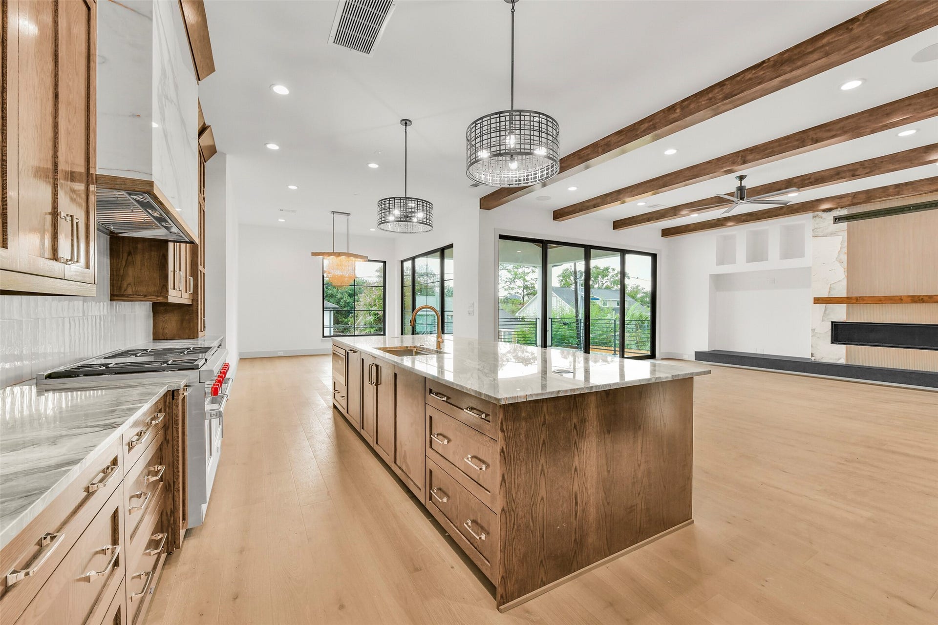 A view across the kitchen island helps convey the simple yet elegant design of what Novel Signature Homes creates for each homeowner. The Thermadore 48 inch 6 burner gas range with double ovens, griddle and professional vent hood is a highlight of the kitchen.