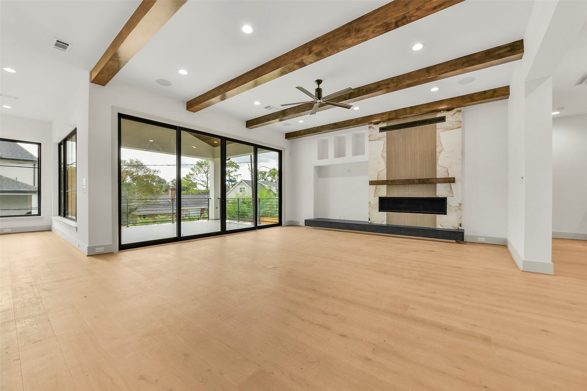 Relax and entertain in the spacious family room, open to the kitchen with direct access to the terrace. The fireplace wall features a custom porcelain surround, a floating hearth and wood mantle.