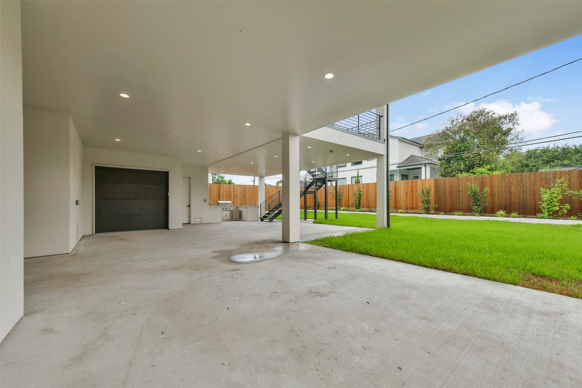 The sweeping covered backyard terrace will feature with an integrated summer kitchen, recessed lighting, built-in speakers and access to the storage space under the home. The voluminous shaded footprint looks directly onto a manicured green lawn with vibrant, structured landscaping, providing a private and protected environment built for seamless grand-scale entertaining.