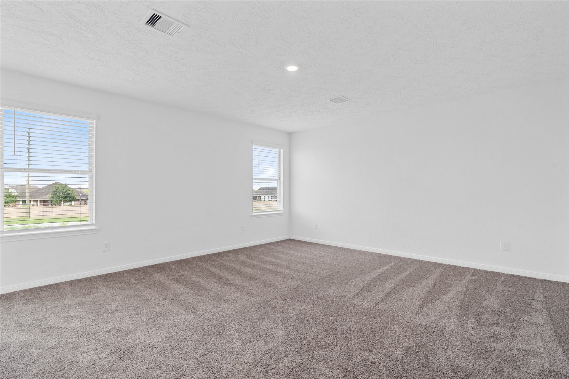 Relax and recharge in this stunning primary suite! This expansive room offers plush carpeting, neutral-toned walls, high ceilings, recessed lighting, large windows fitted with privacy blinds, and an added sitting areaperfect for unwinding after a long day.