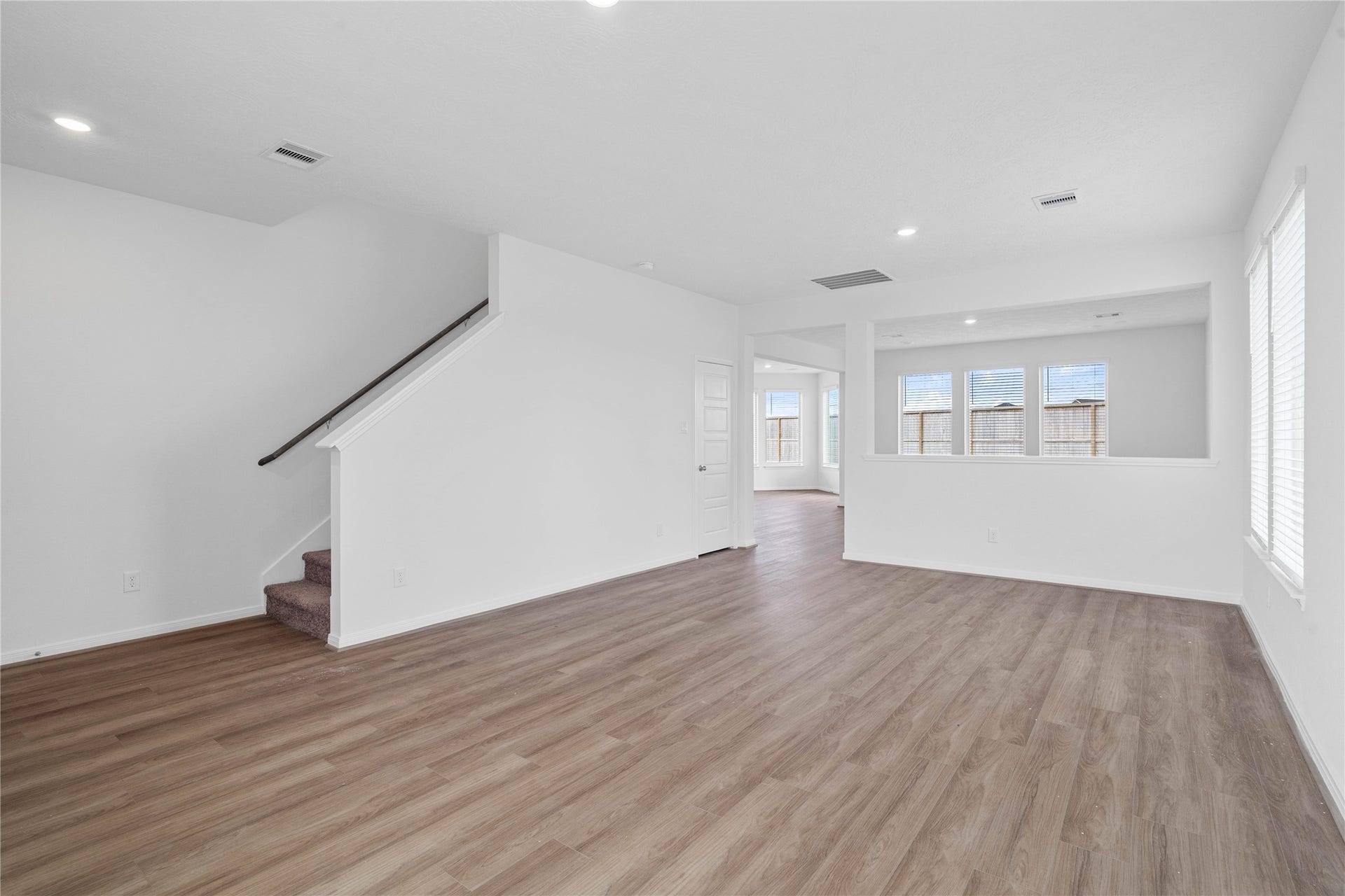 Upon entering you find a lovely formal living and dining space showcasing neutral paint, beautiful vinyl plank flooring, high ceilings, recessed lighting, windows with privacy blinds, coat closet, and staircase leading to the second floor!