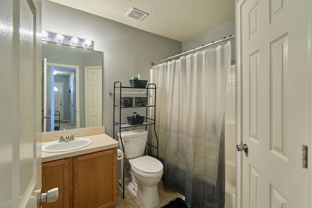 5934 Spring Sunrise Drive, Richmond, TX 77407 Fresh, functional, and thoughtfully arranged with a shower/tub combination and convenient vanity storage.