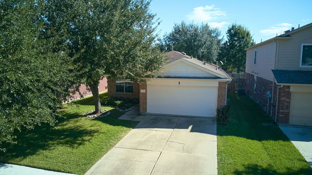 5934 Spring Sunrise Drive, Richmond, TX 77407 Arrive home to a welcoming driveway, attached garage, and the natural beauty of mature surrounding trees.