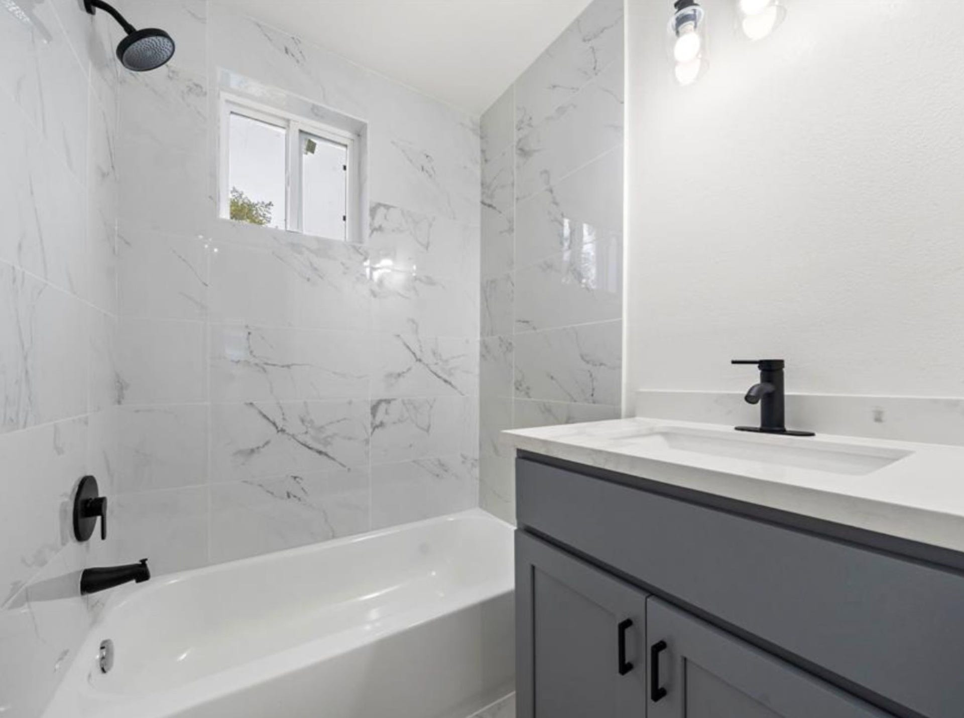 2312 Lucinda Street, Houston, TX 77004 Bathroom with tiled tub/shower and updated vanity.