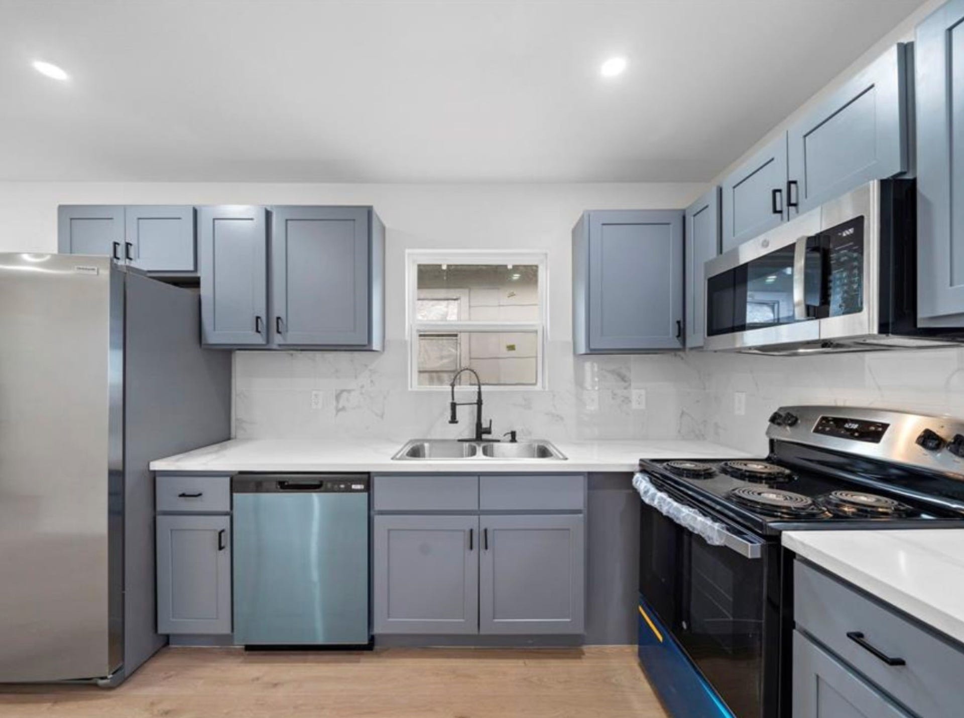 2312 Lucinda Street, Houston, TX 77004 Kitchen with blue cabinetry and stainless steel appliances.
