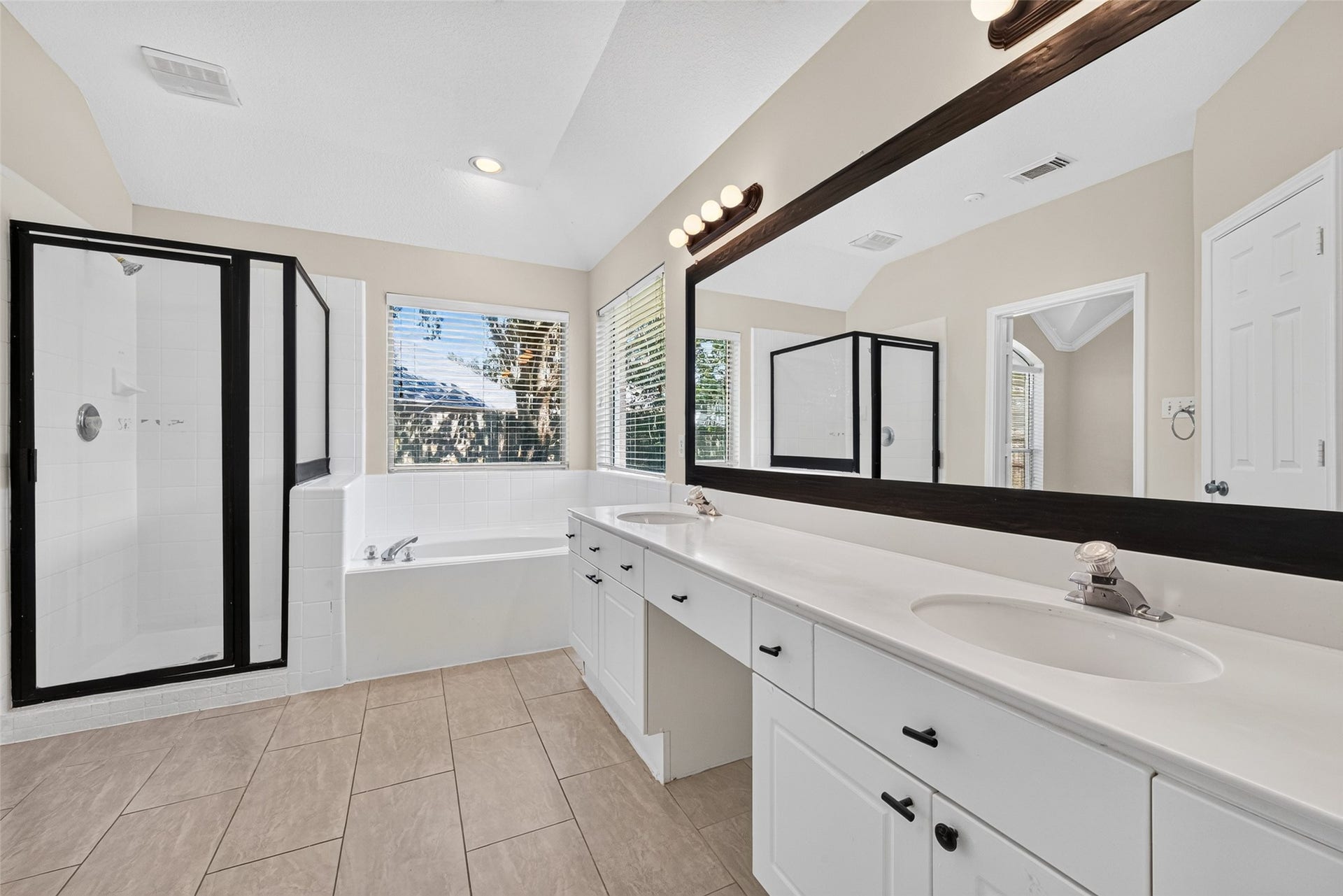 4903 Chappel Hill Drive, Missouri City, TX 77459 Primary bathroom features a modern stand-in shower, a soaking tub, and a large vanity with dual sinks