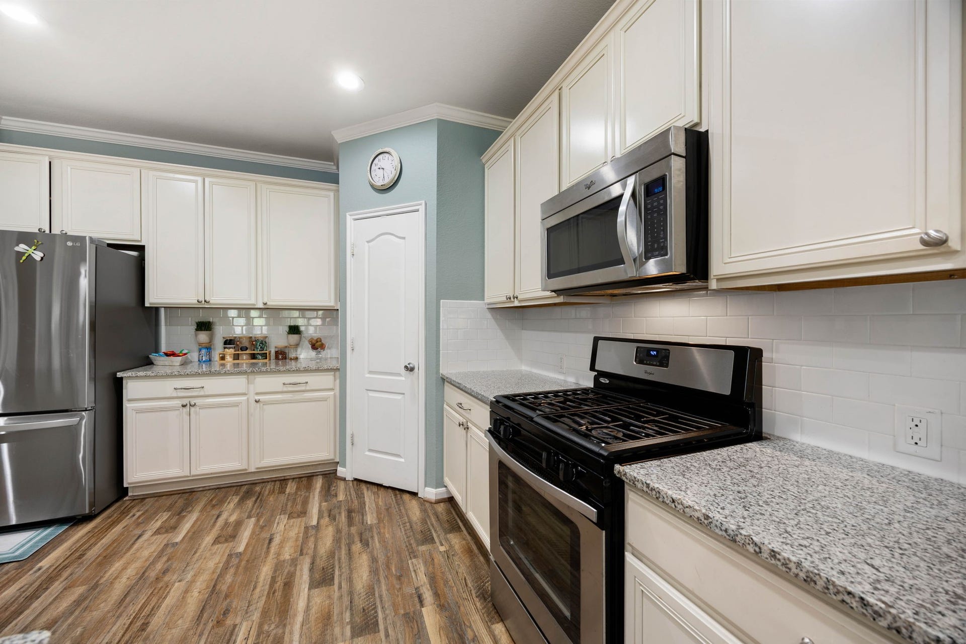 24114 Buffalo Cove Lane, Katy, TX 77493 White cabinetry, a tile backsplash and stainless steel gas range give the kitchen a bright, clean feel.