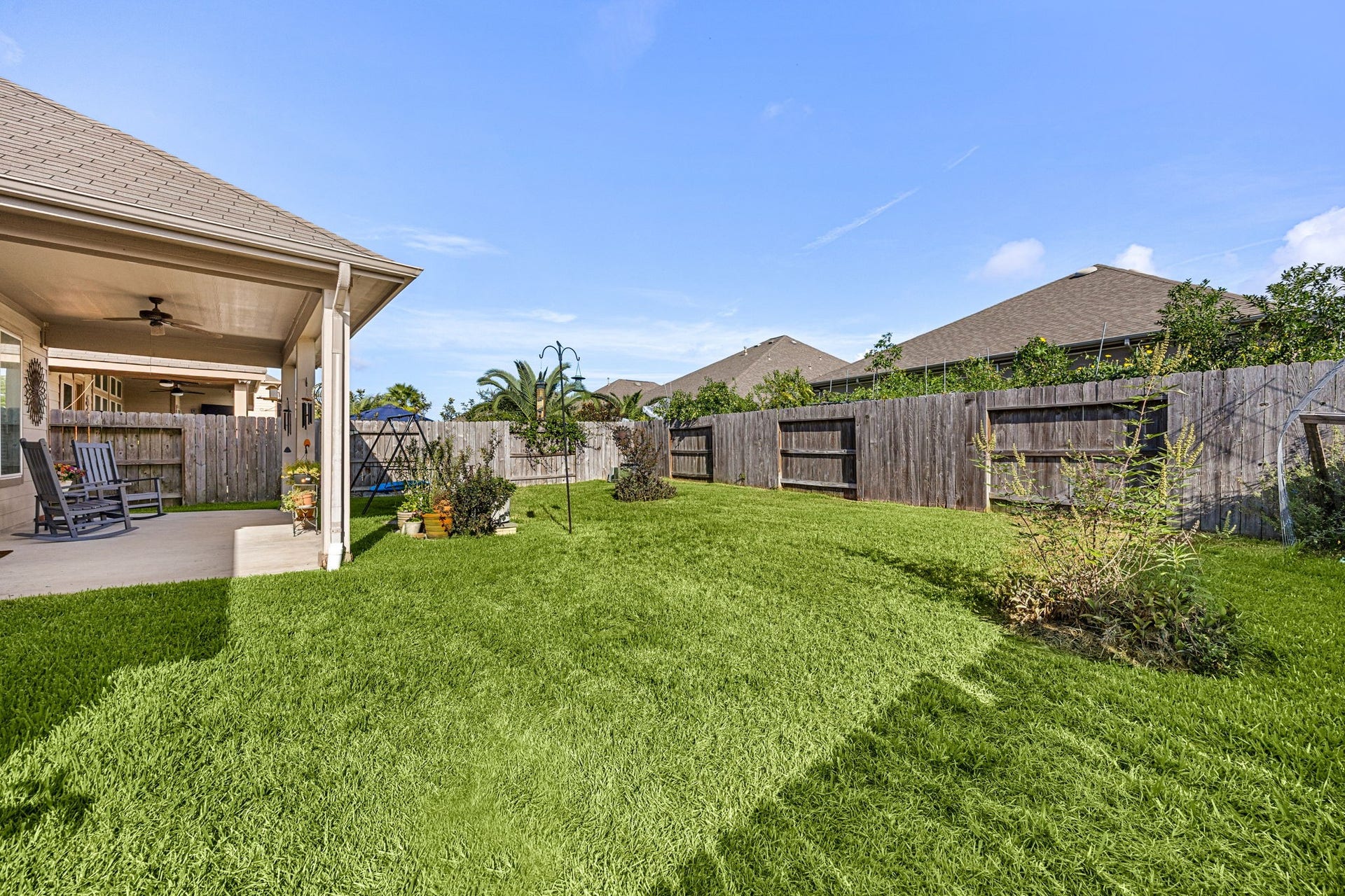 24114 Buffalo Cove Lane, Katy, TX 77493 The backyard offers a large, fully fenced grassy space with mature landscaping along the back fence line.