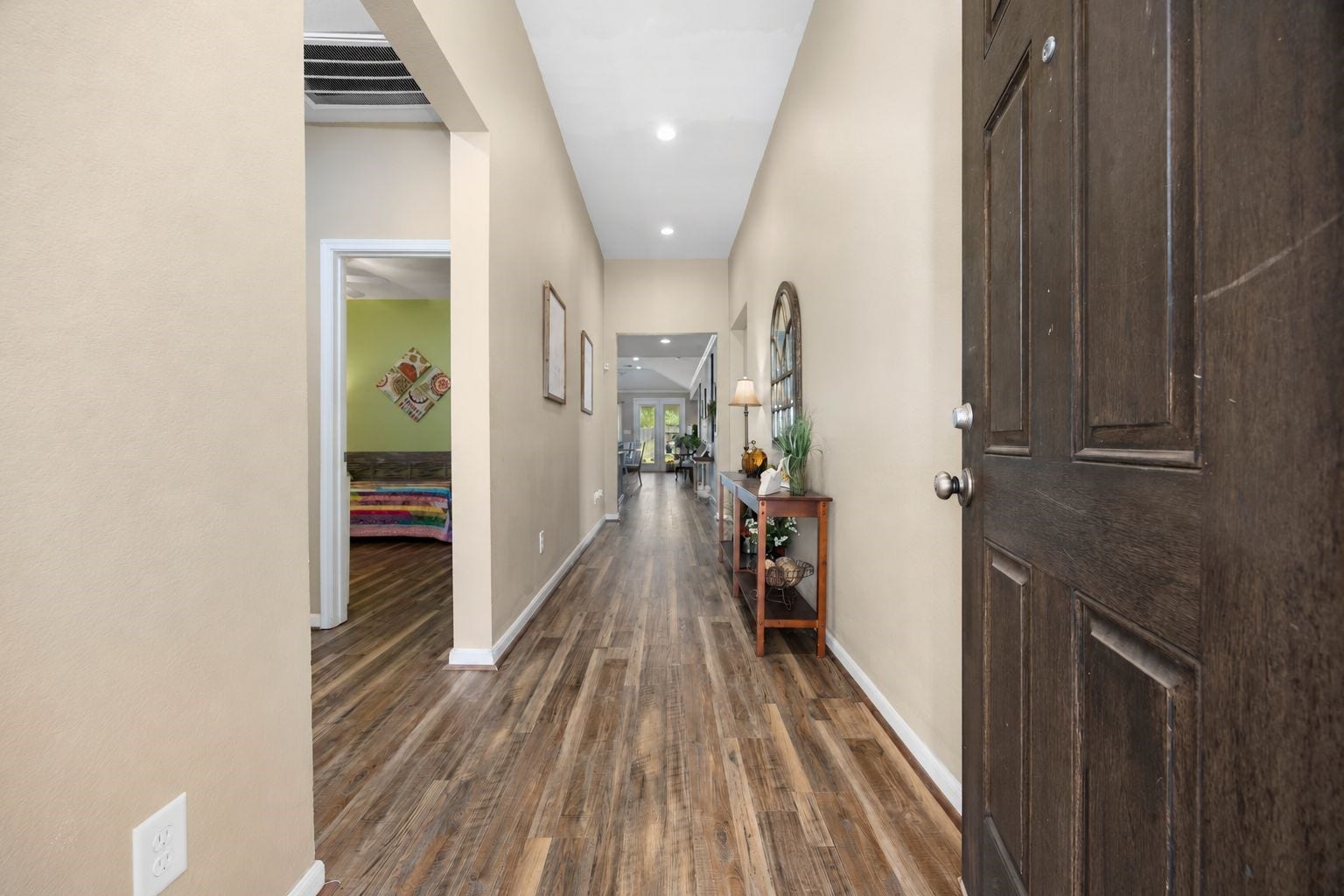 24114 Buffalo Cove Lane, Katy, TX 77493 Step through the entry into a welcoming foyer, where wood-look flooring extends down the hallway toward the open living area beyond.