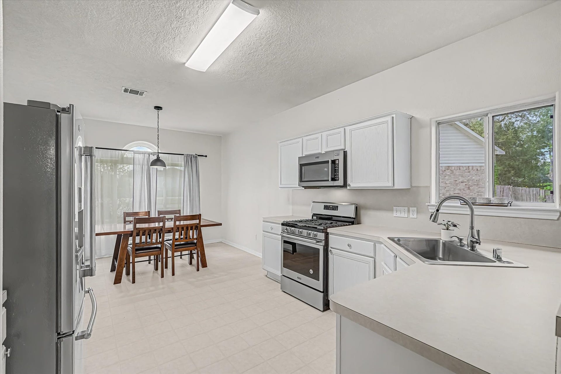 Spacious kitchen features an abundance of cabinetry and generous counter space.