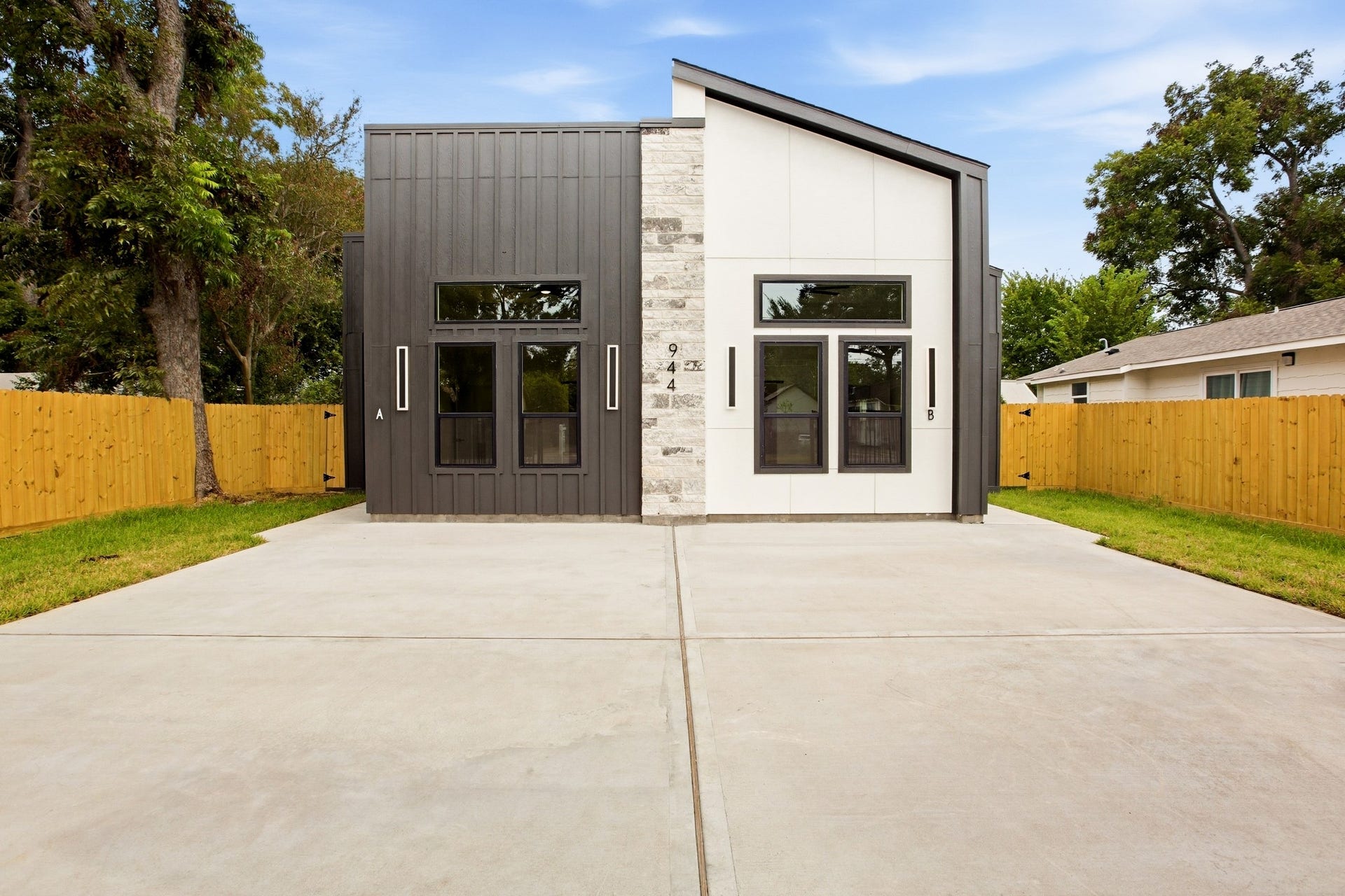 Contemporary faade framed by a spacious driveway and private yard.