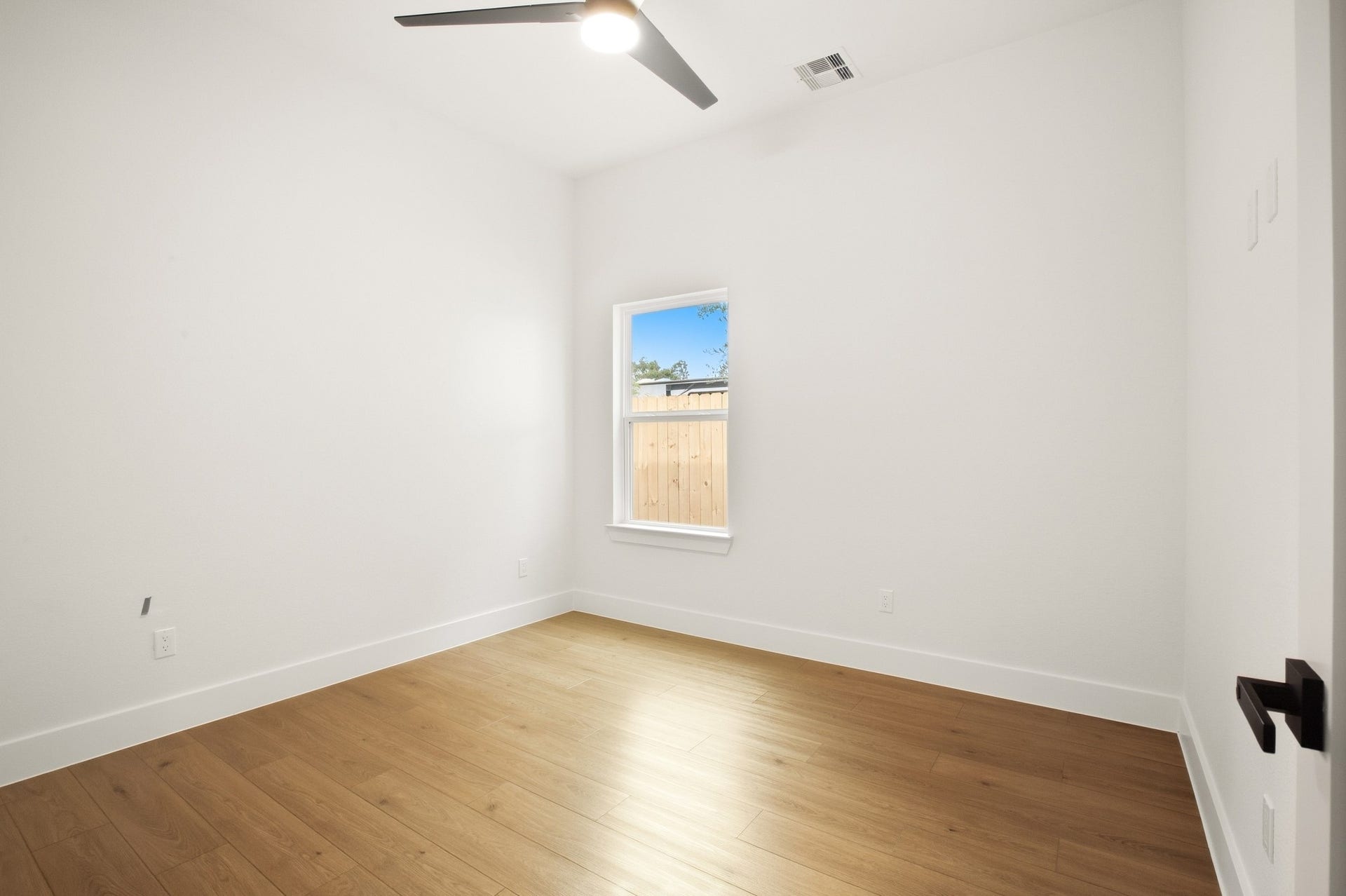 Comfortable bedroom with natural light and warm wood flooring.