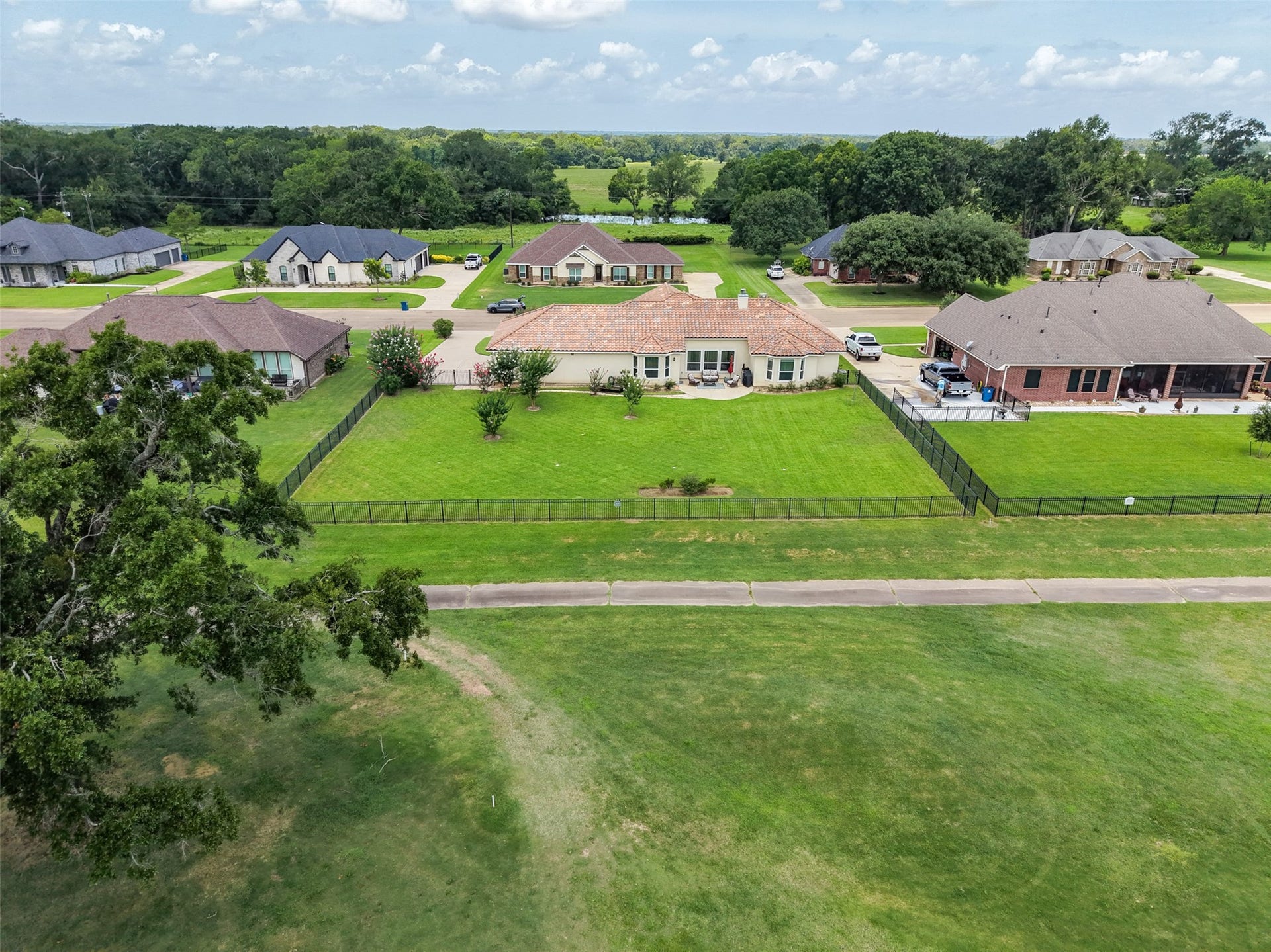 230 Lawrence Marshall Drive, Hempstead, TX 77445 Scenic aerial view showcasing the expansive homesite, fenced backyard, and open green space beyond.