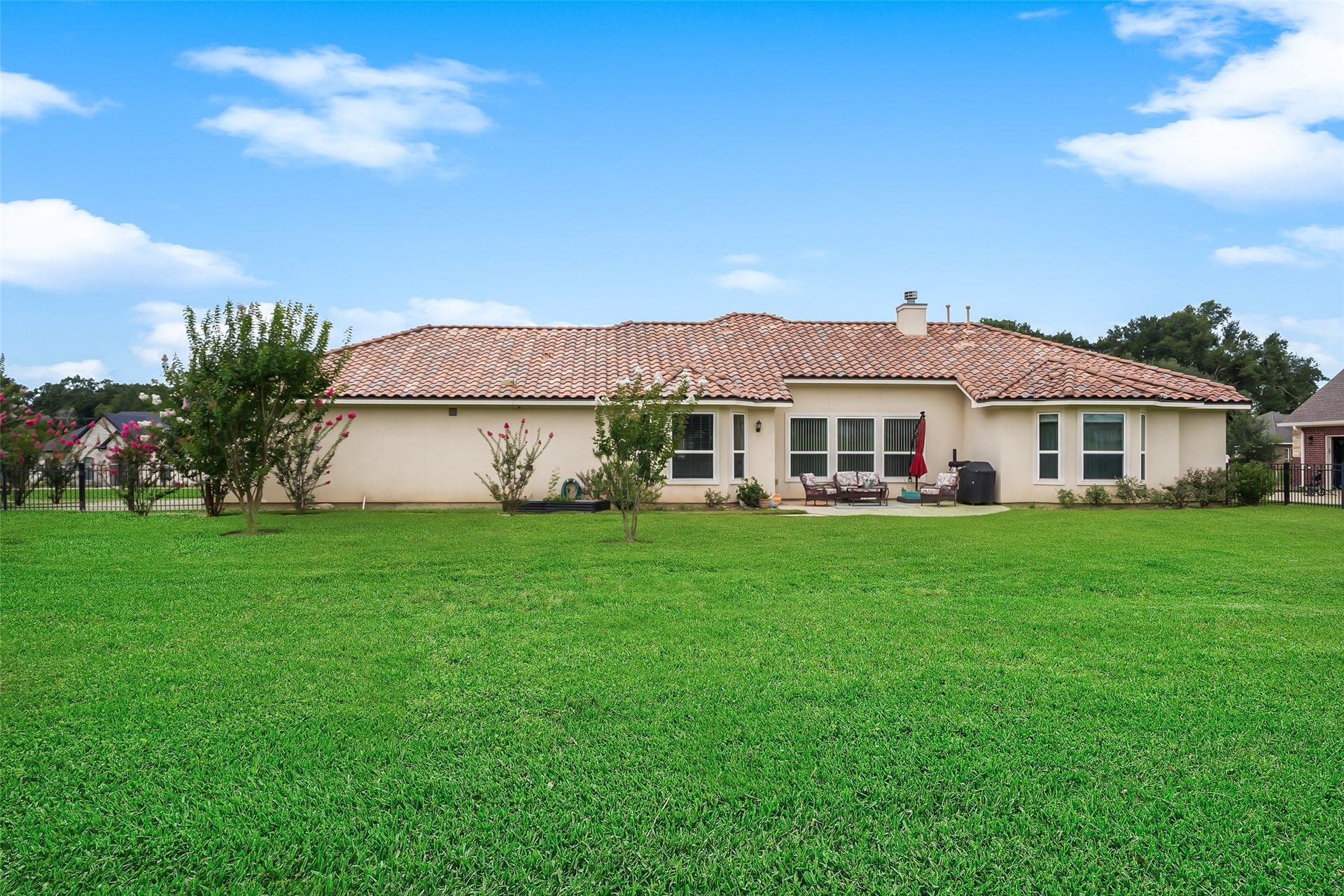 230 Lawrence Marshall Drive, Hempstead, TX 77445 Rear exterior of the home featuring a spacious backyard, brick faade, and easy access to the patio, offering plenty of room to enjoy the peaceful country setting.