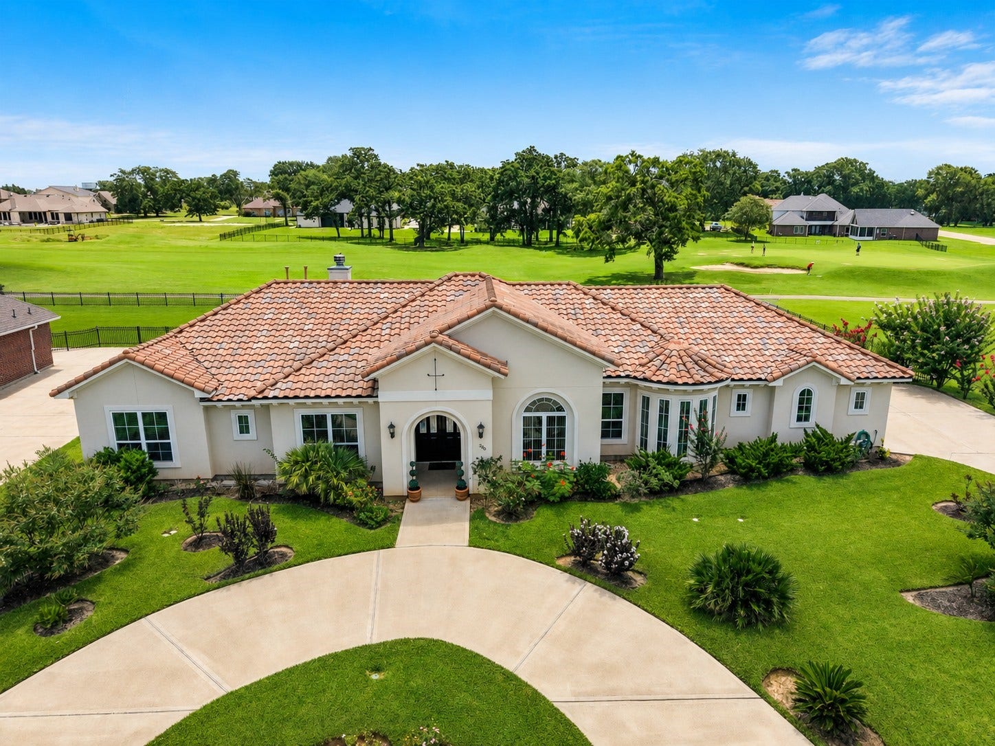 230 Lawrence Marshall Drive, Hempstead, TX 77445 Elegant Mediterranean-style home with a circular driveway overlooking the 14th fairway in gated Legendary Oaks.
