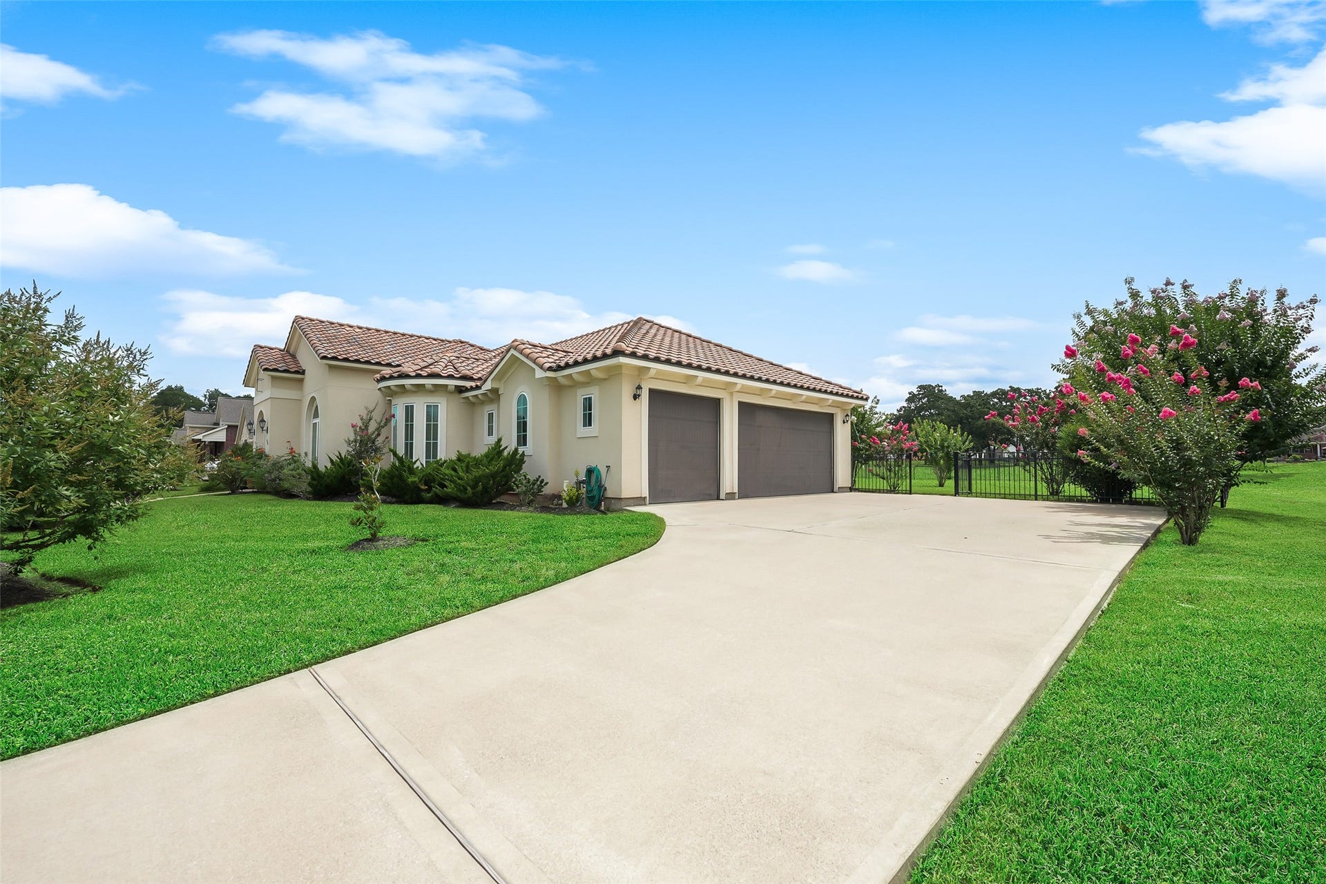 230 Lawrence Marshall Drive, Hempstead, TX 77445 Oversized concrete driveway leading to the side-entry garage with beautifully maintained landscaping