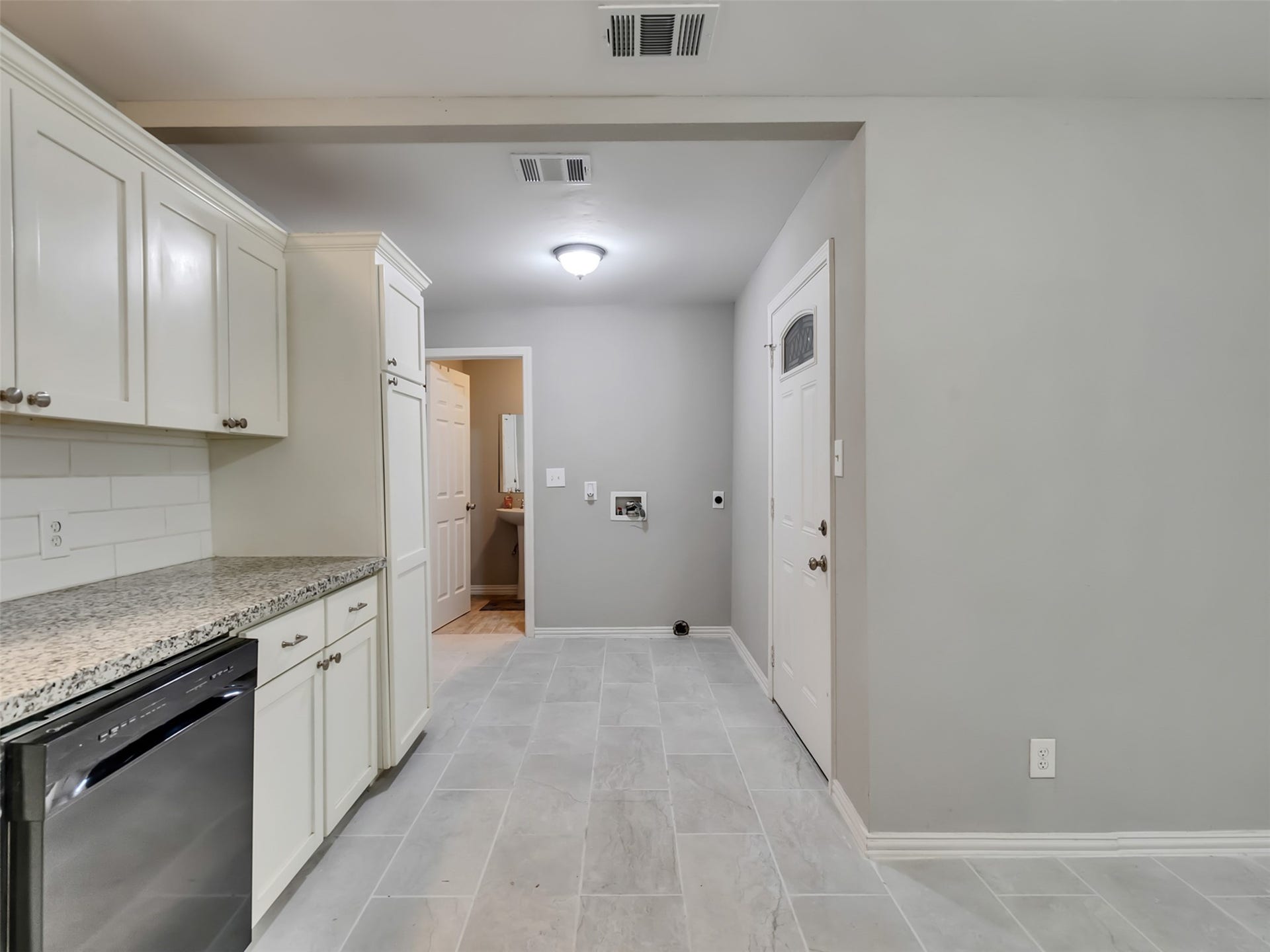 12313 23rd Street, Santa Fe, TX 77510 Kitchen looking at back door, washer/dryer connections and secondary bathroom.